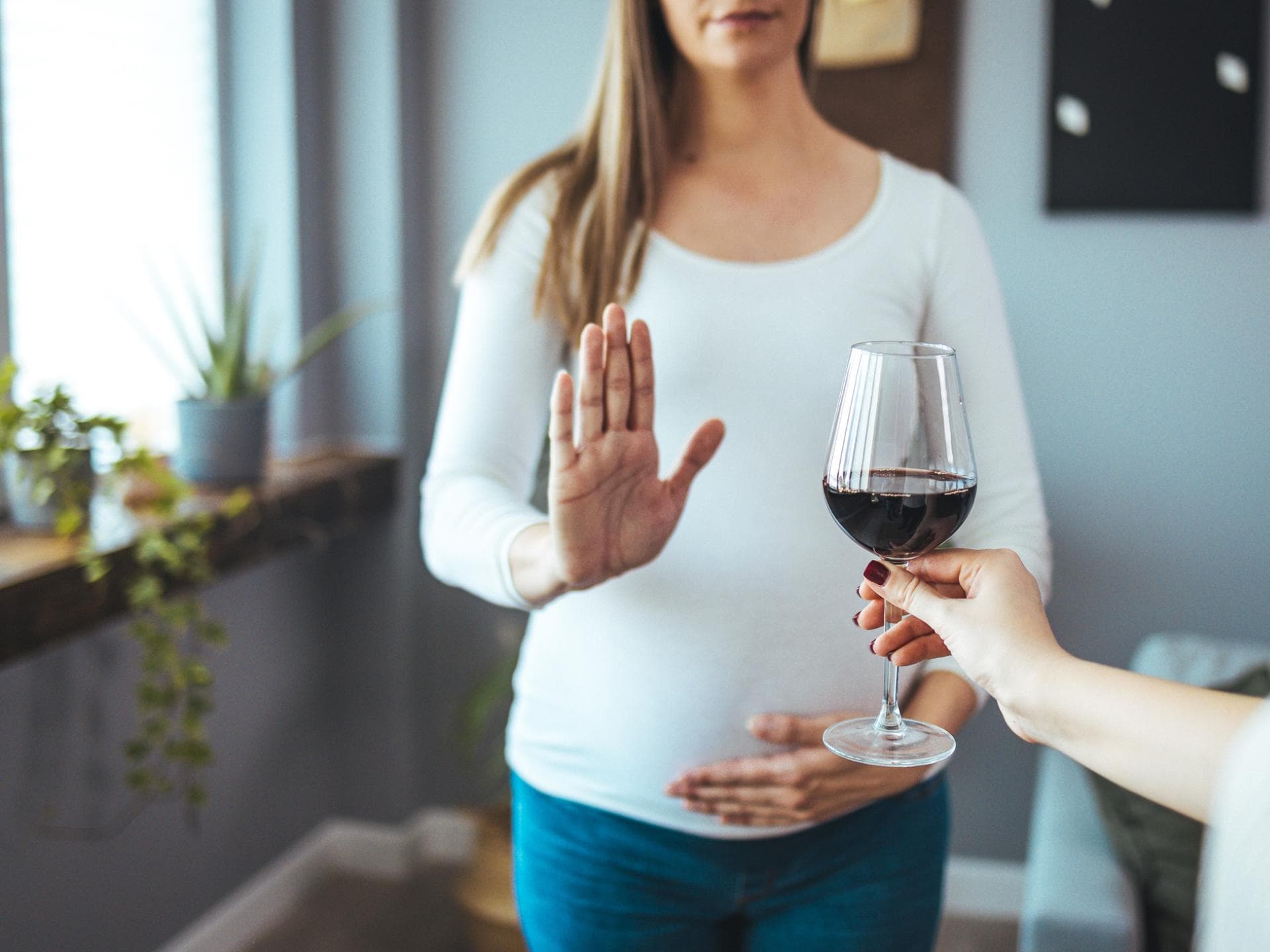 Frau lehnt Glas Rotwein ab