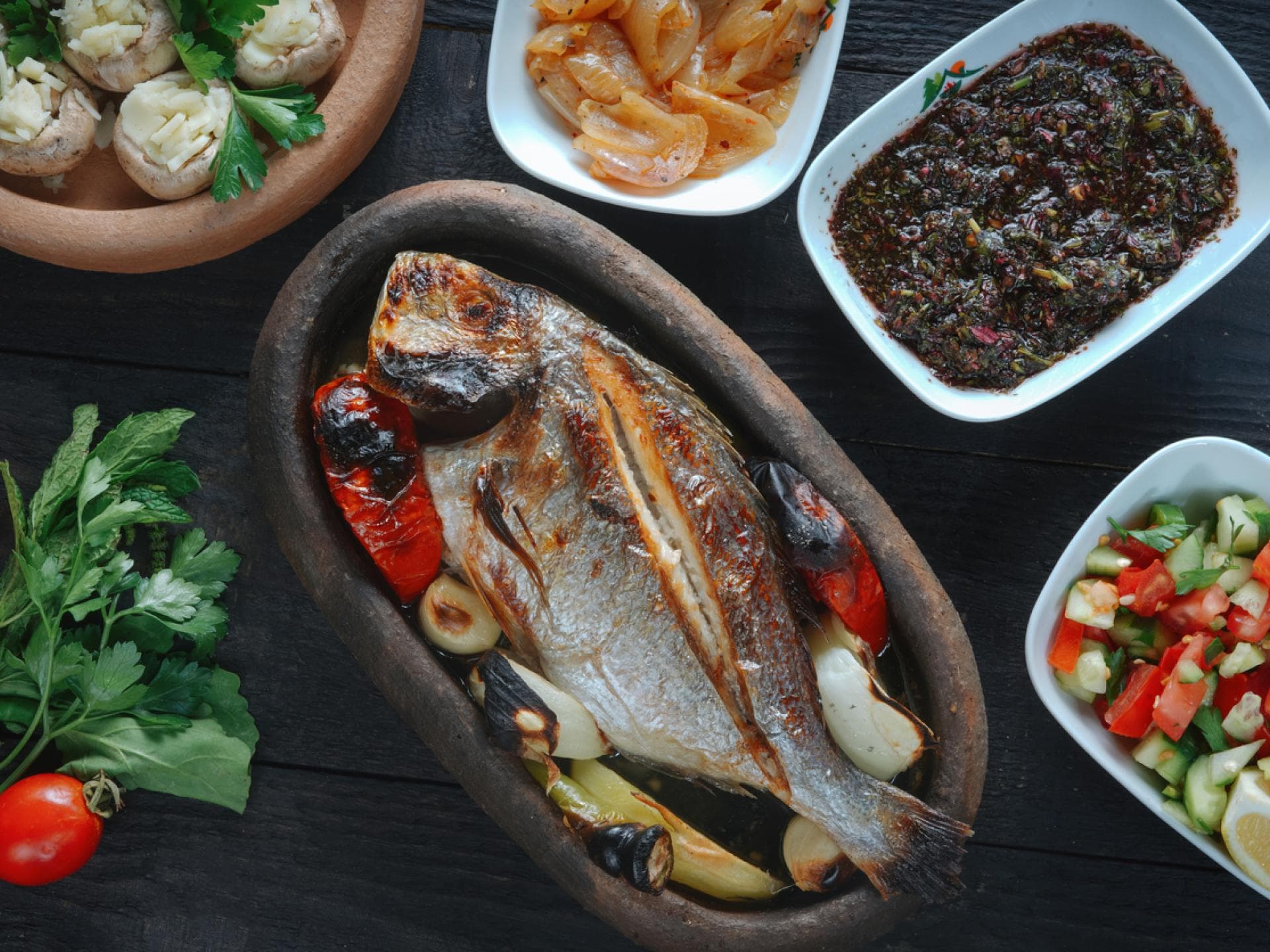 Gegrillter Fisch mit Salat und mediterranen Beilagen