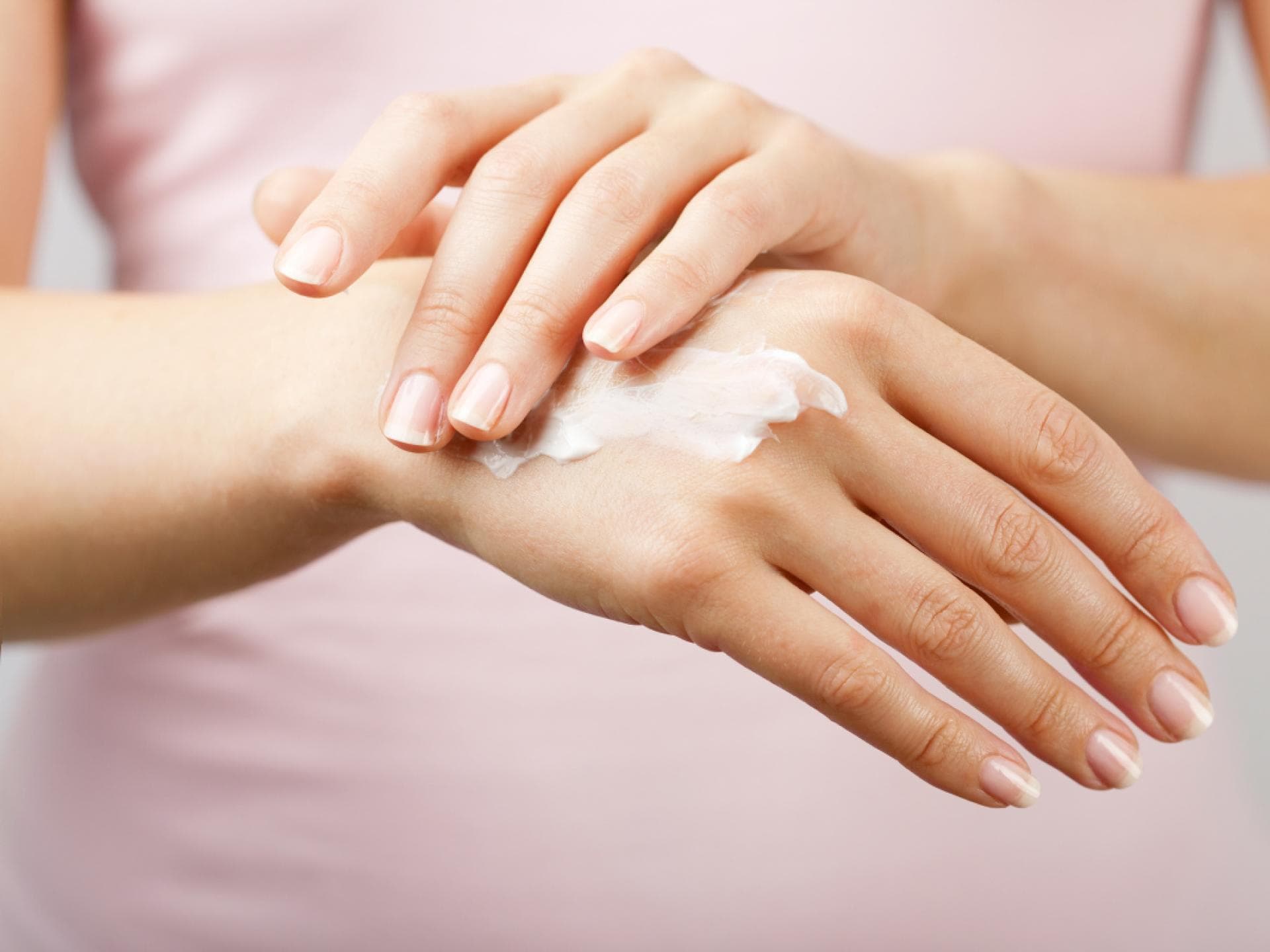 DIY-Handcreme aus nur wenigen Zutaten Frau cremt sich Handrücken ein