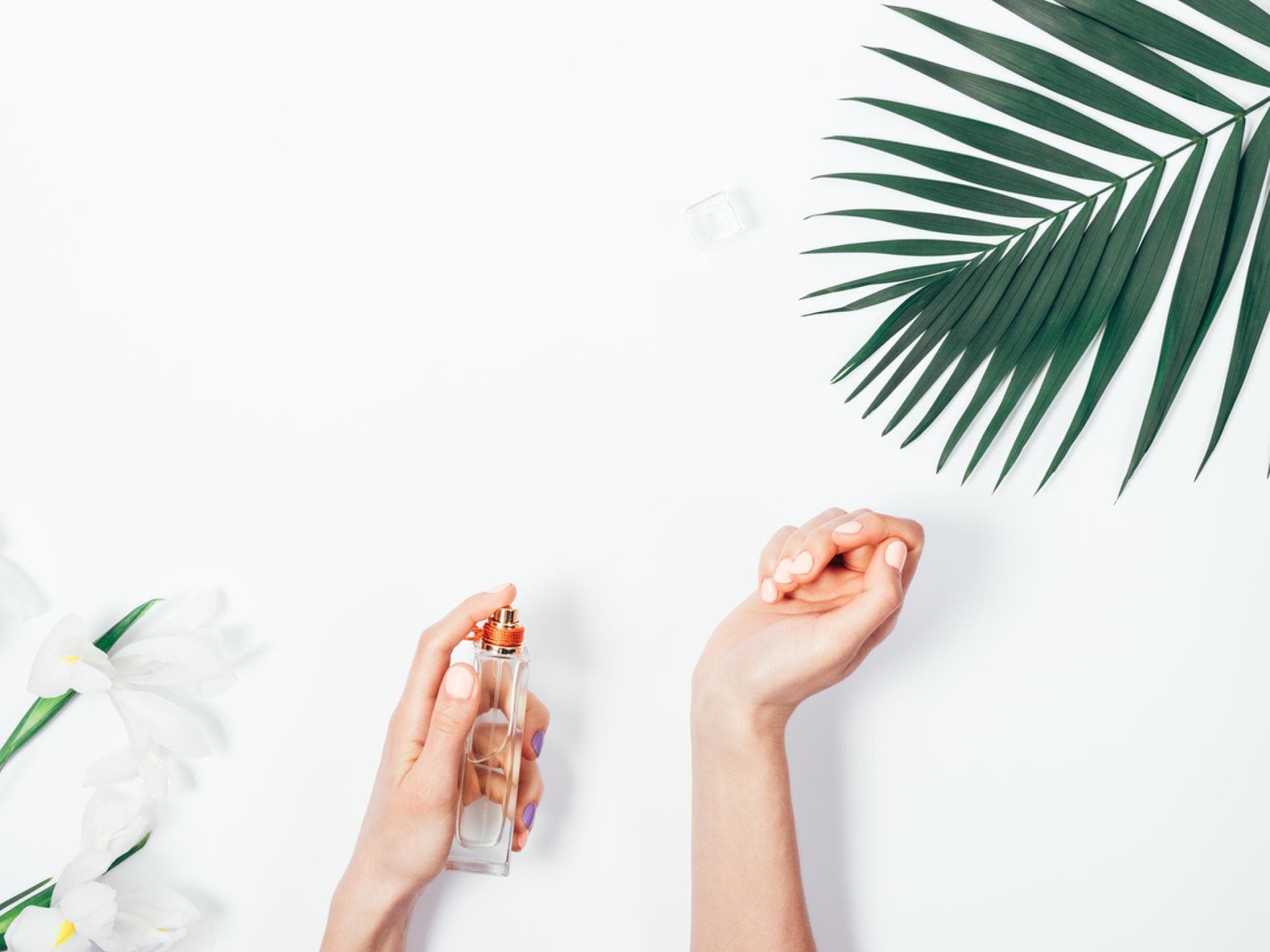 Frau sprüht Parfum auf das Handgelenk