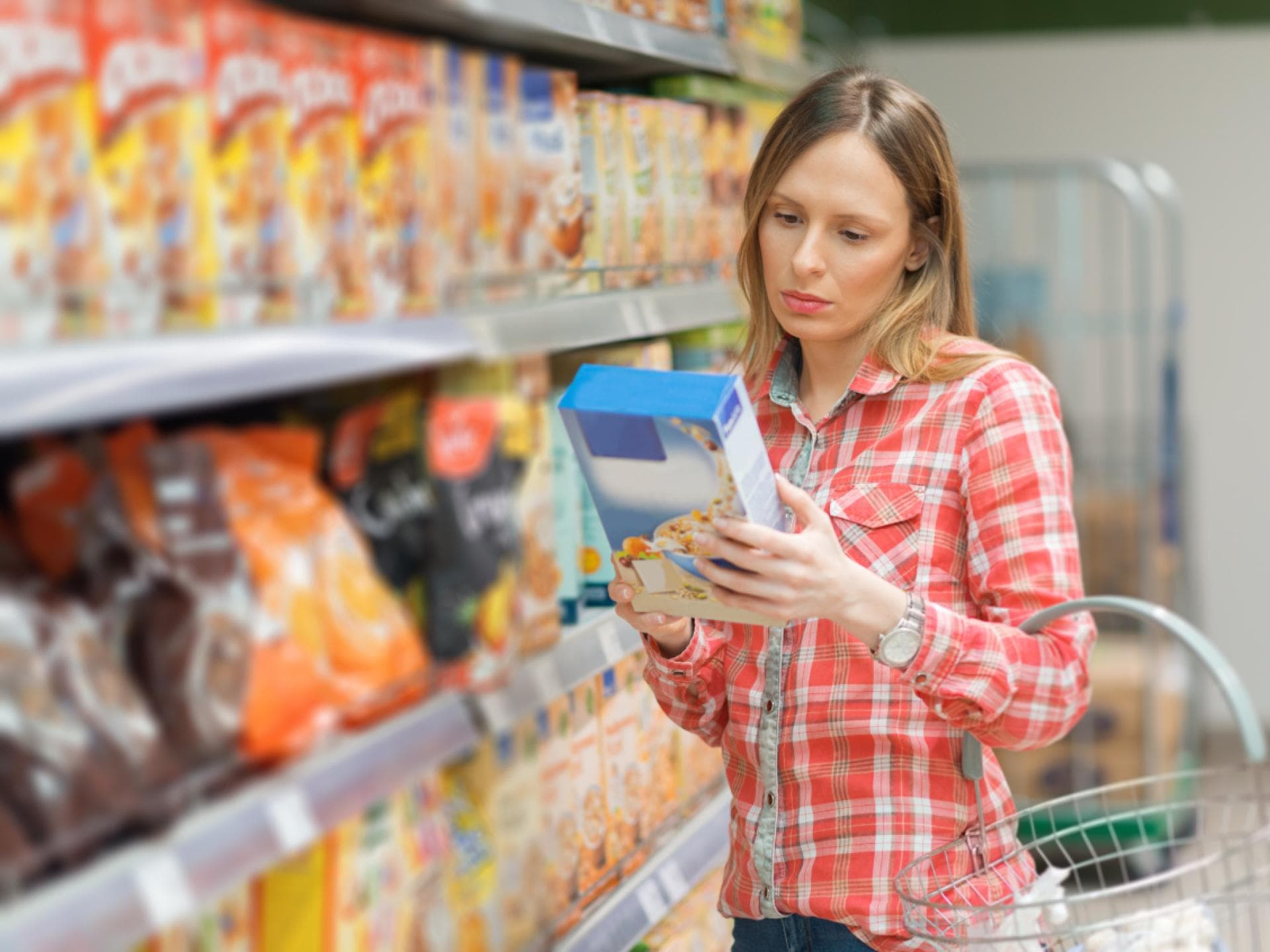Frau schaut auf Nährwertangaben im Supermarkt