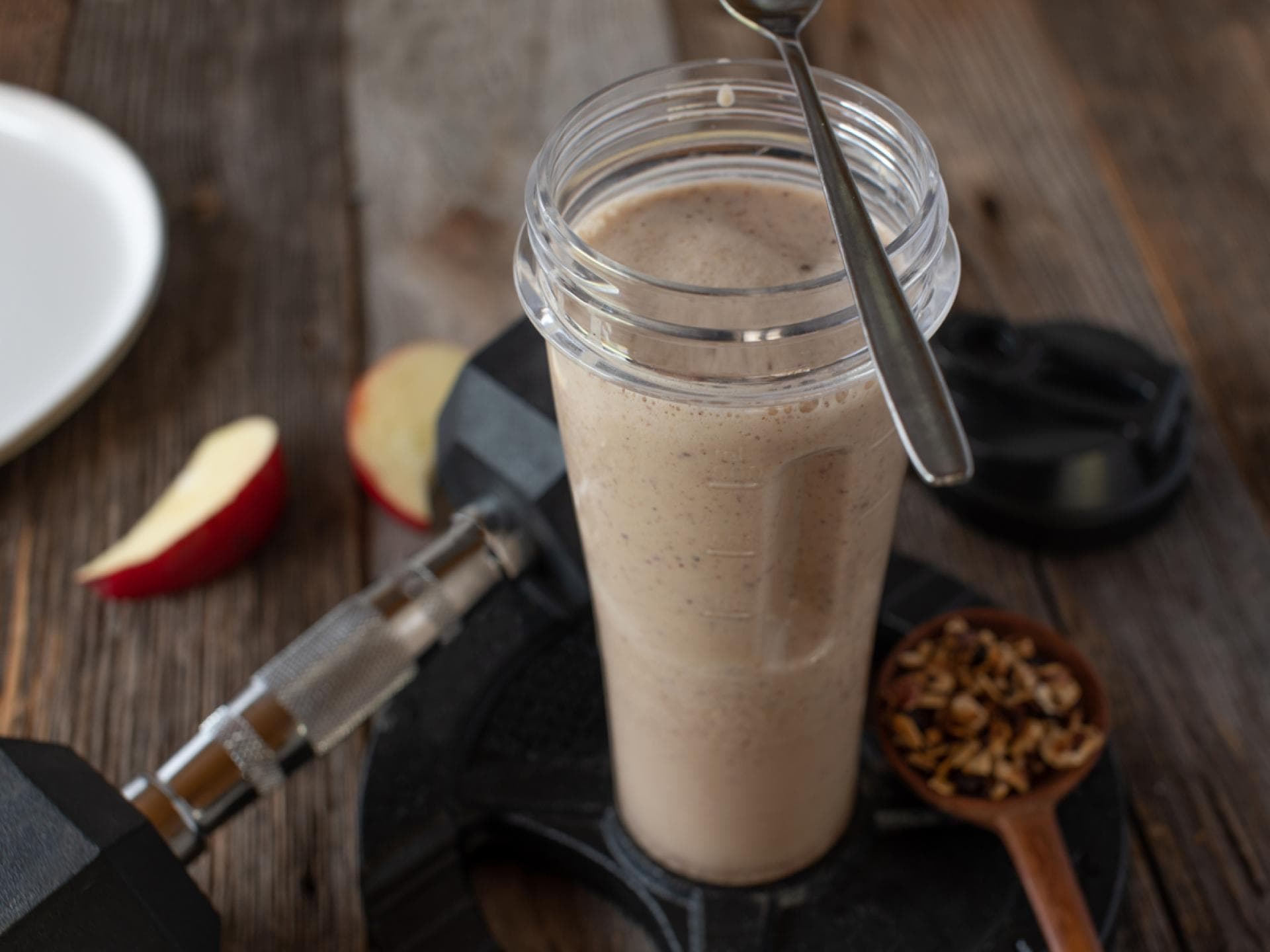 Proteinshae und Hantel auf Holztisch