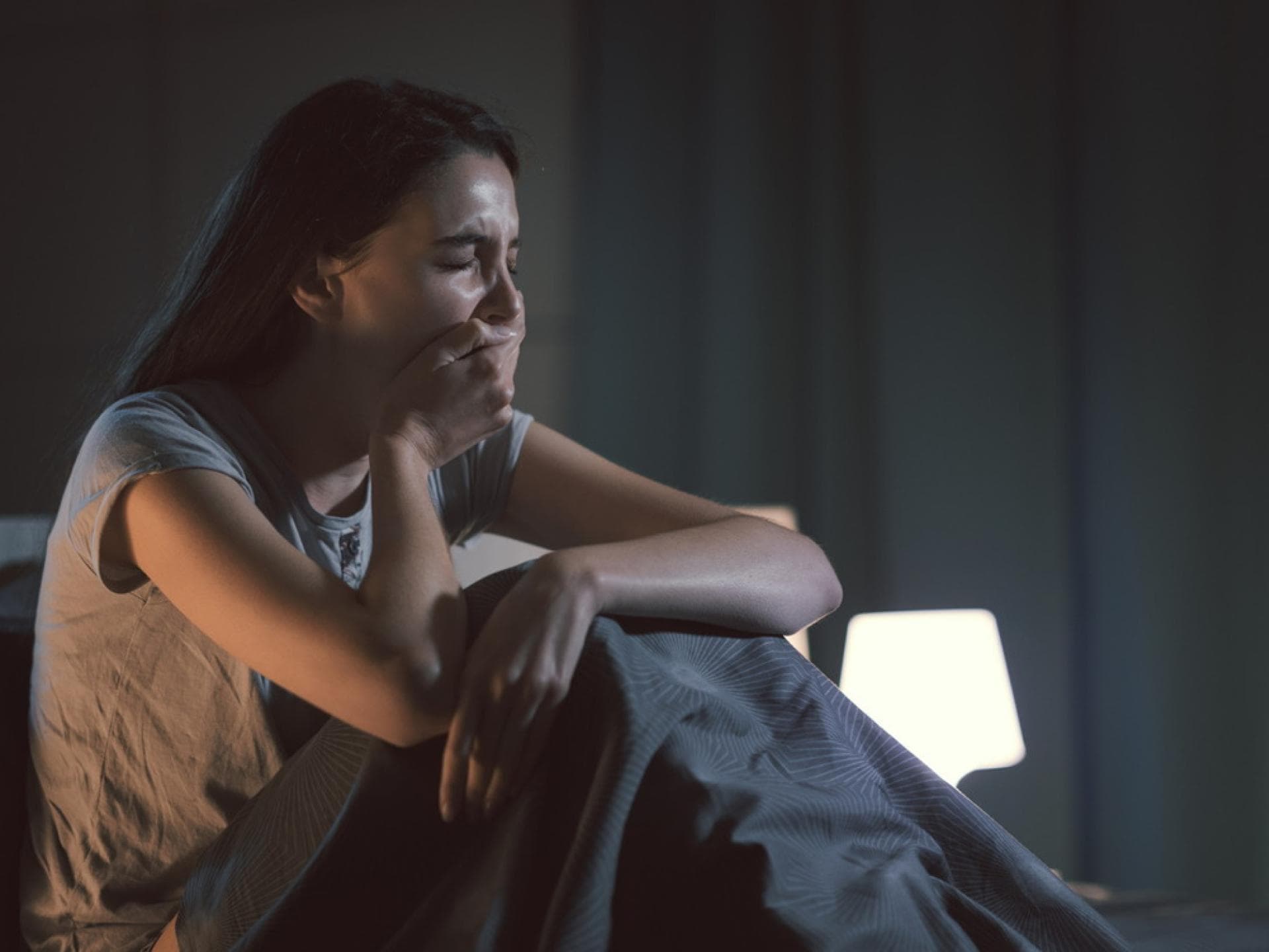 Müde Frau gähnt mitten in der Nacht im Bett