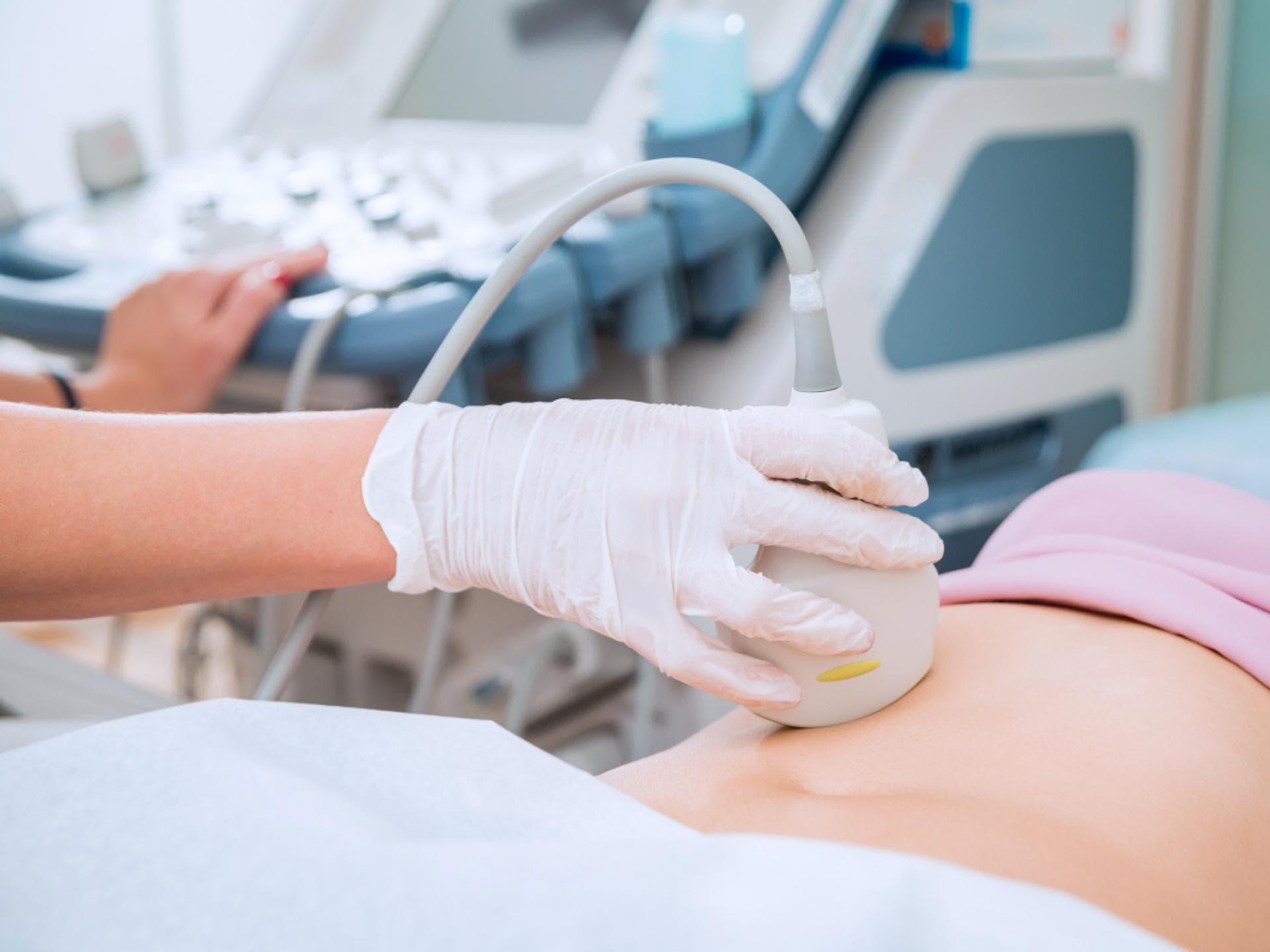 Ärztin untersucht Bauch einer Patientin mit Ultraschall