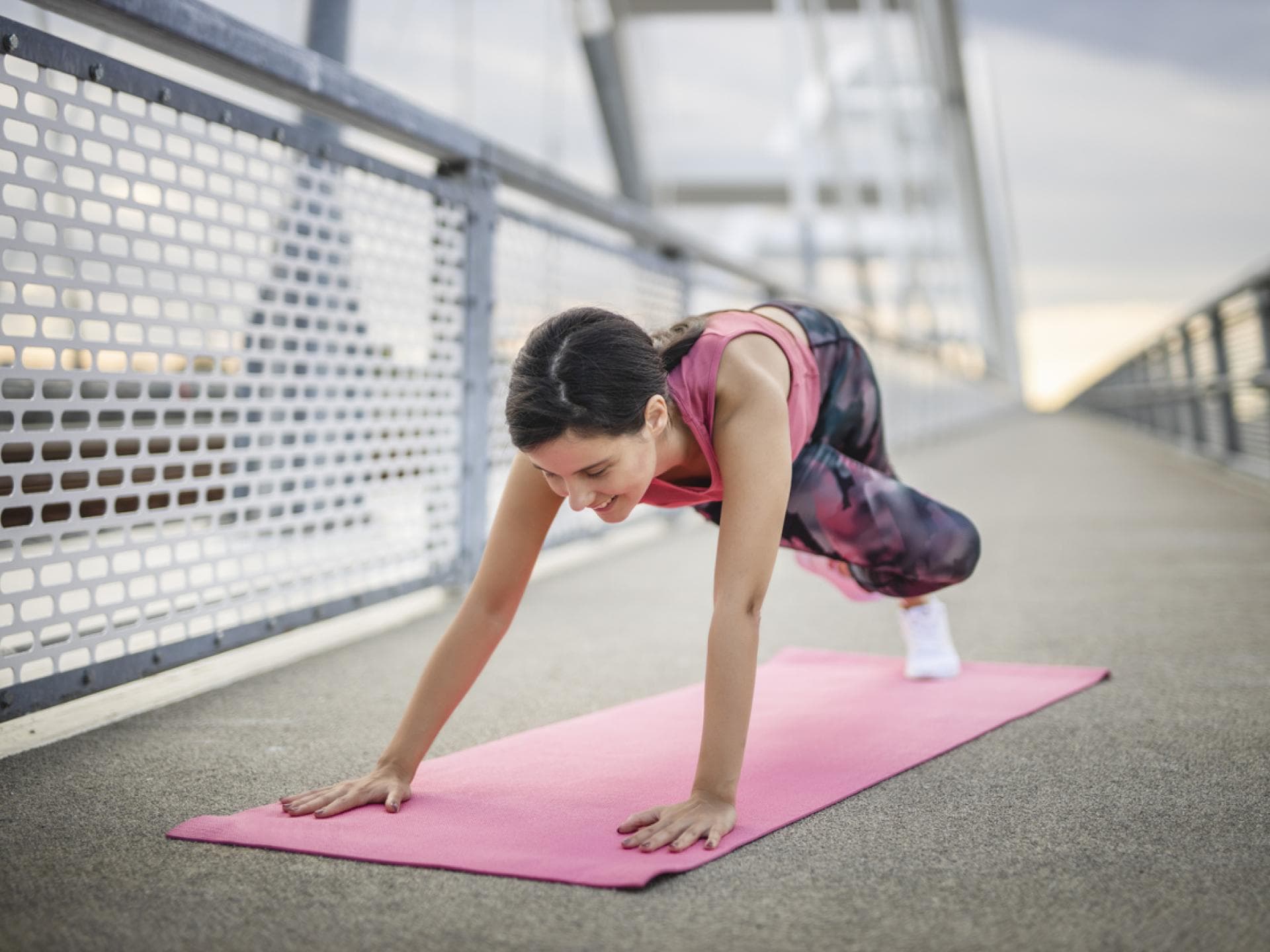 Mountain Climber mit Twist Frau macht Mountain Climbers mit Rumpfdrehung auf Brücke
