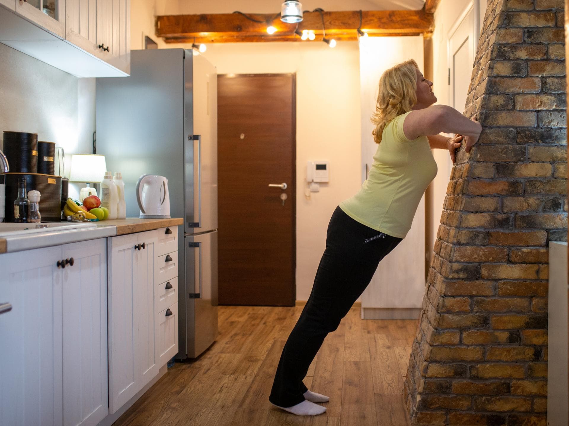 Frau macht Push ups gegen Wand
