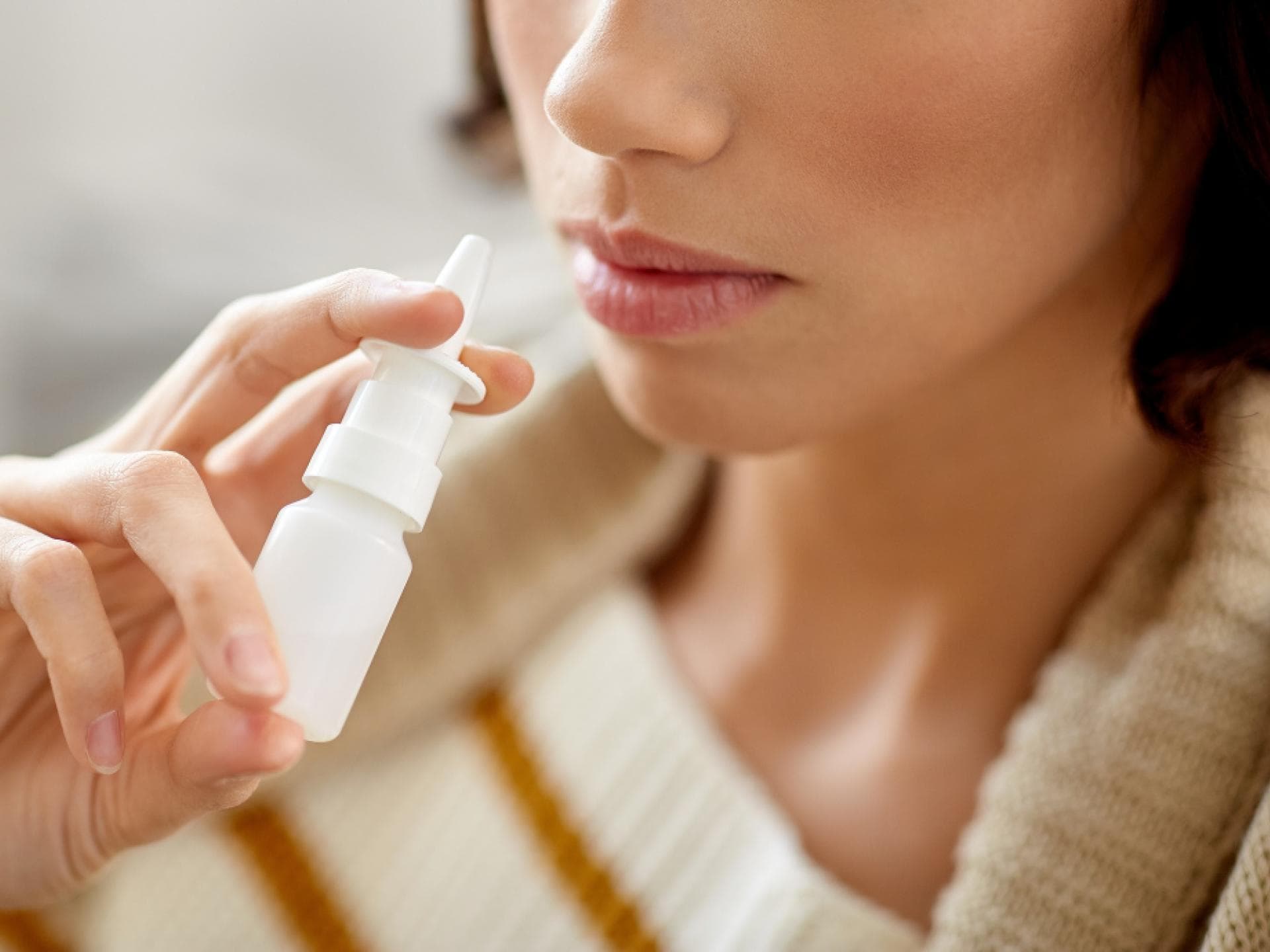 Nasenspray letzte Hilfe bei Heuschnupfen Frau mit Nasenspray in der Hand