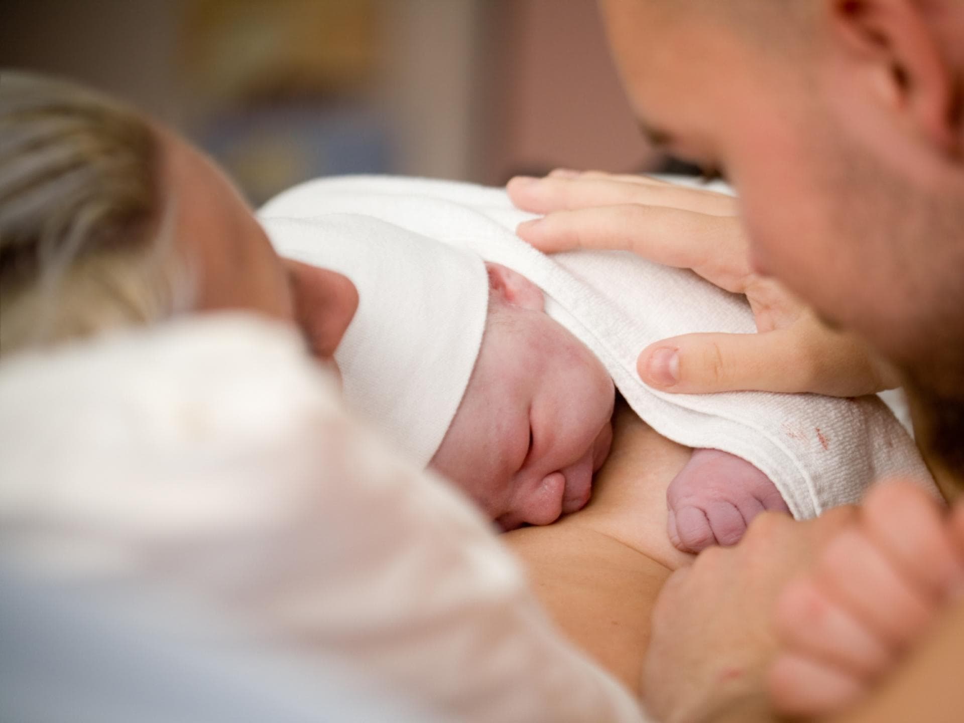 Neugeborenes schläft auf Brust von Mutter