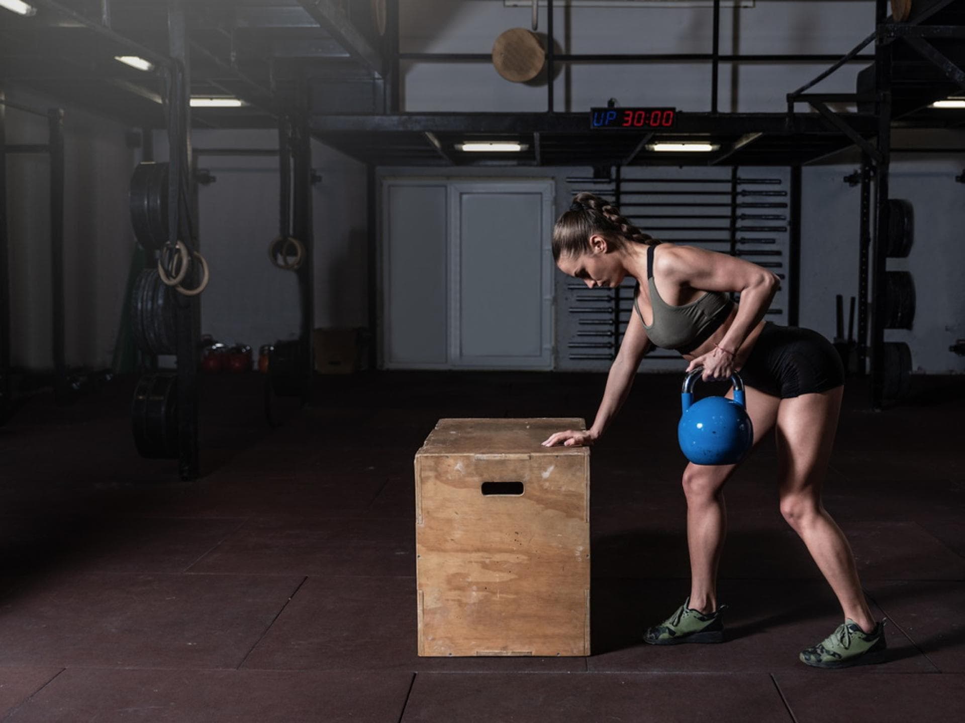 Frau mit Kettlebell macht einarmiges Rudern