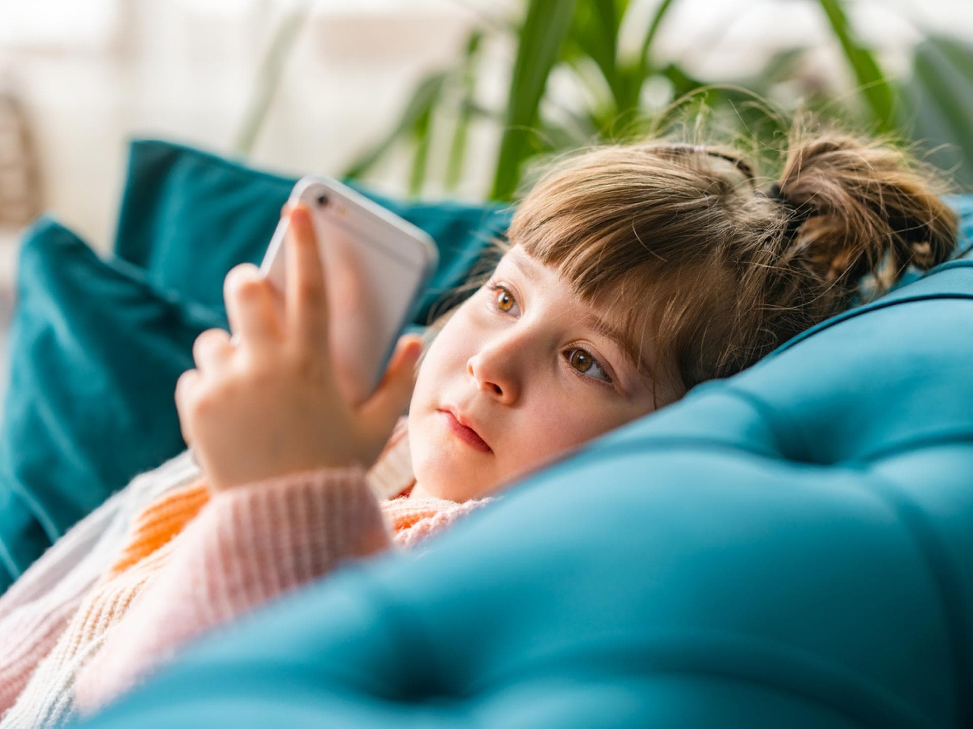 Kleines Mädchen starrt auf Handy