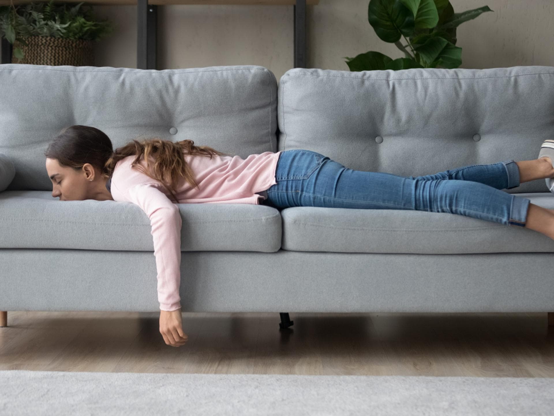 Erschöpfte Frau liegt auf der Couch