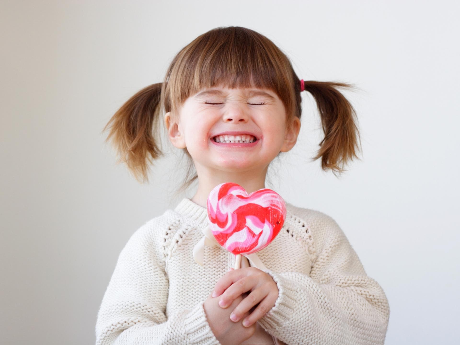 Kleines Mädchen lacht mit Riesenlolli