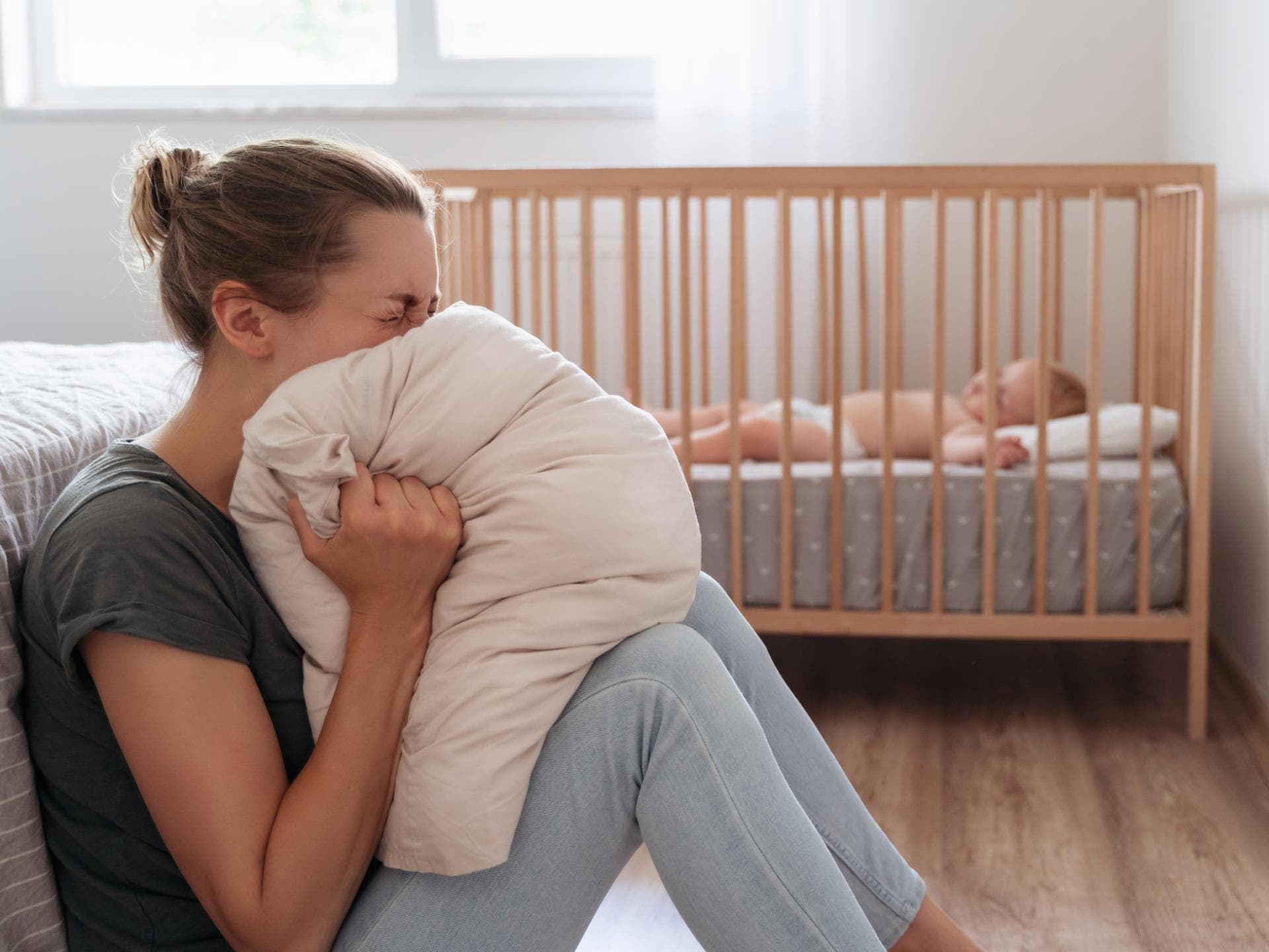 Depressive Mutter, die vor Verzweiflung im Kissen schreit