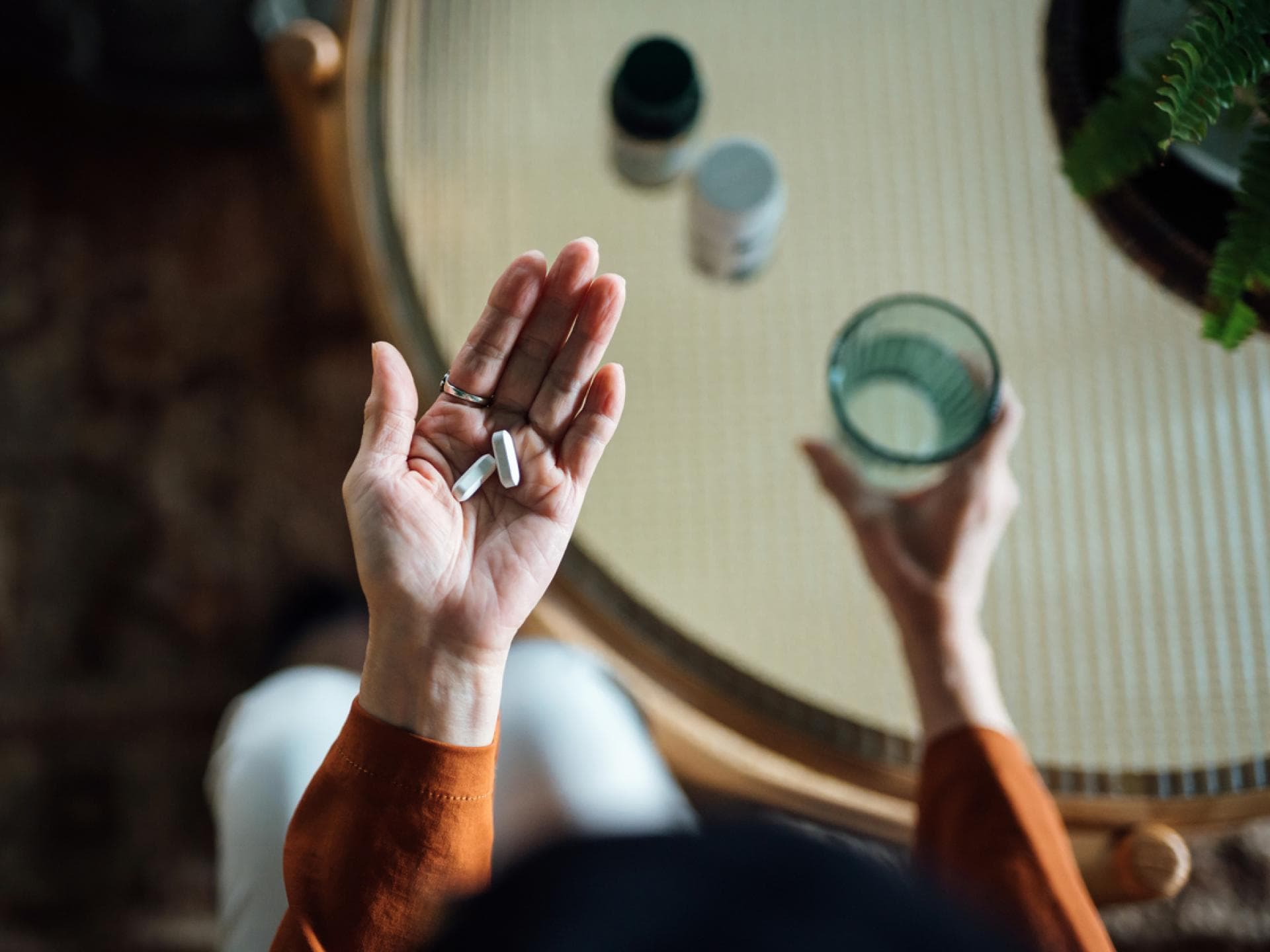 Frau hält Vitaminpräparate in der Hand