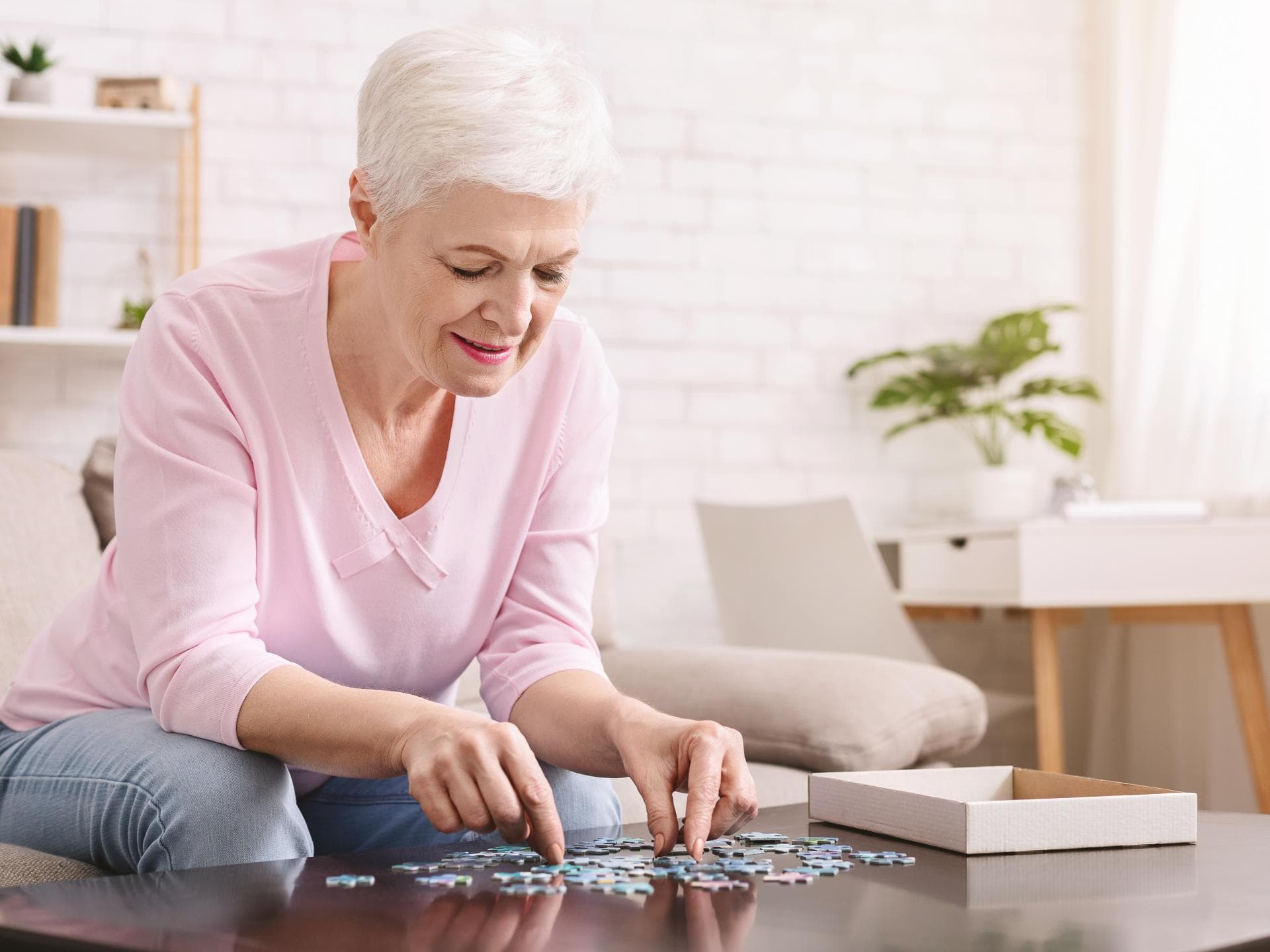 Eine Behandlung der Helicobacter pylori-Infektion kann das Risiko für Demenz senken. Frau mit Alzheimer löst Puzzle