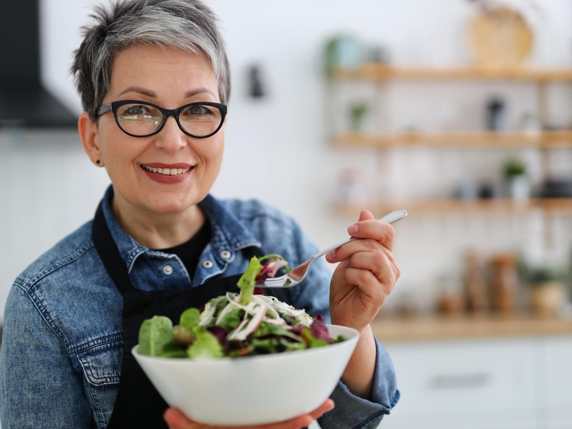 Frau im mittleren Alter isst Salat