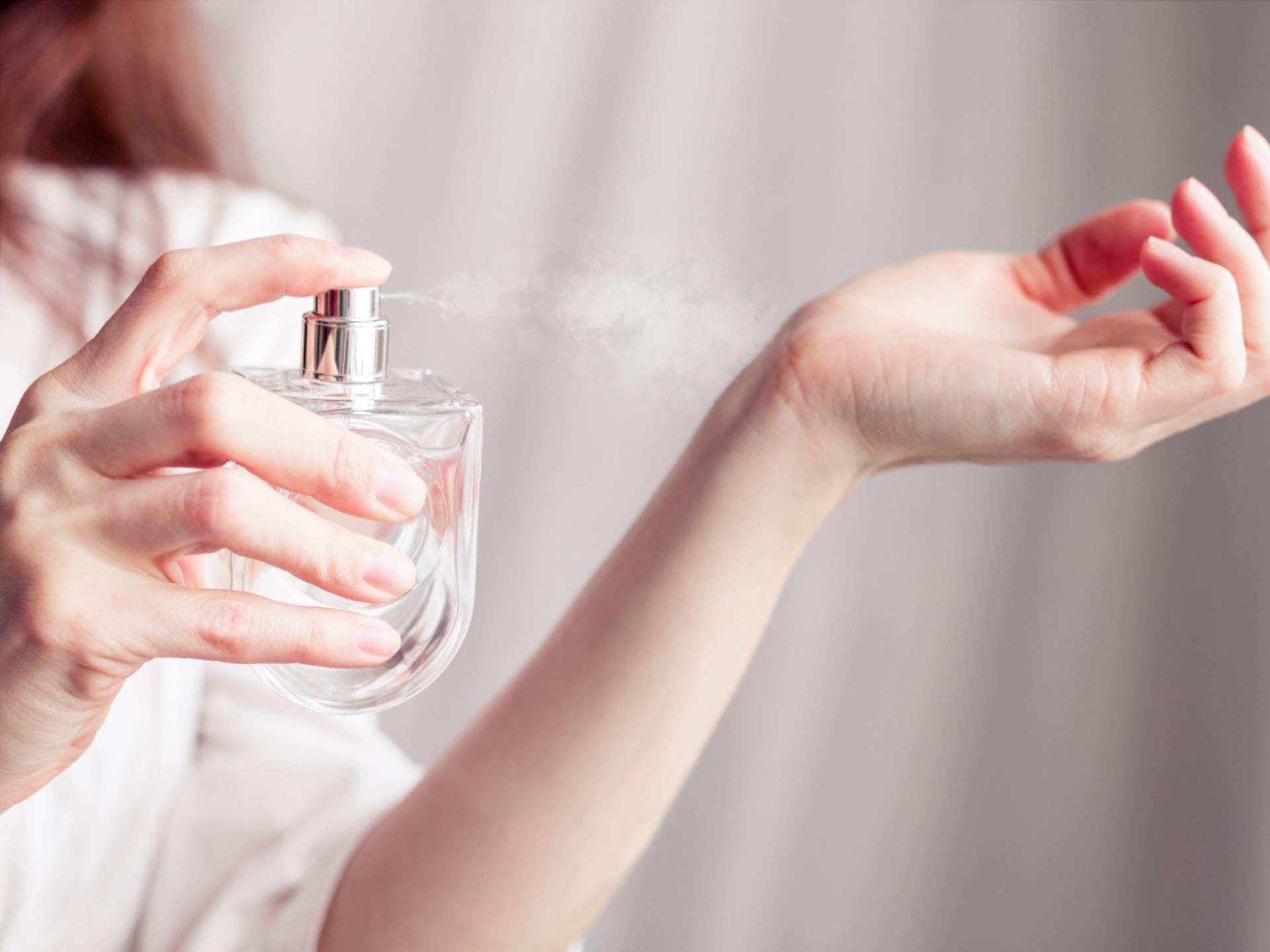 Frau trägt Parfum auf