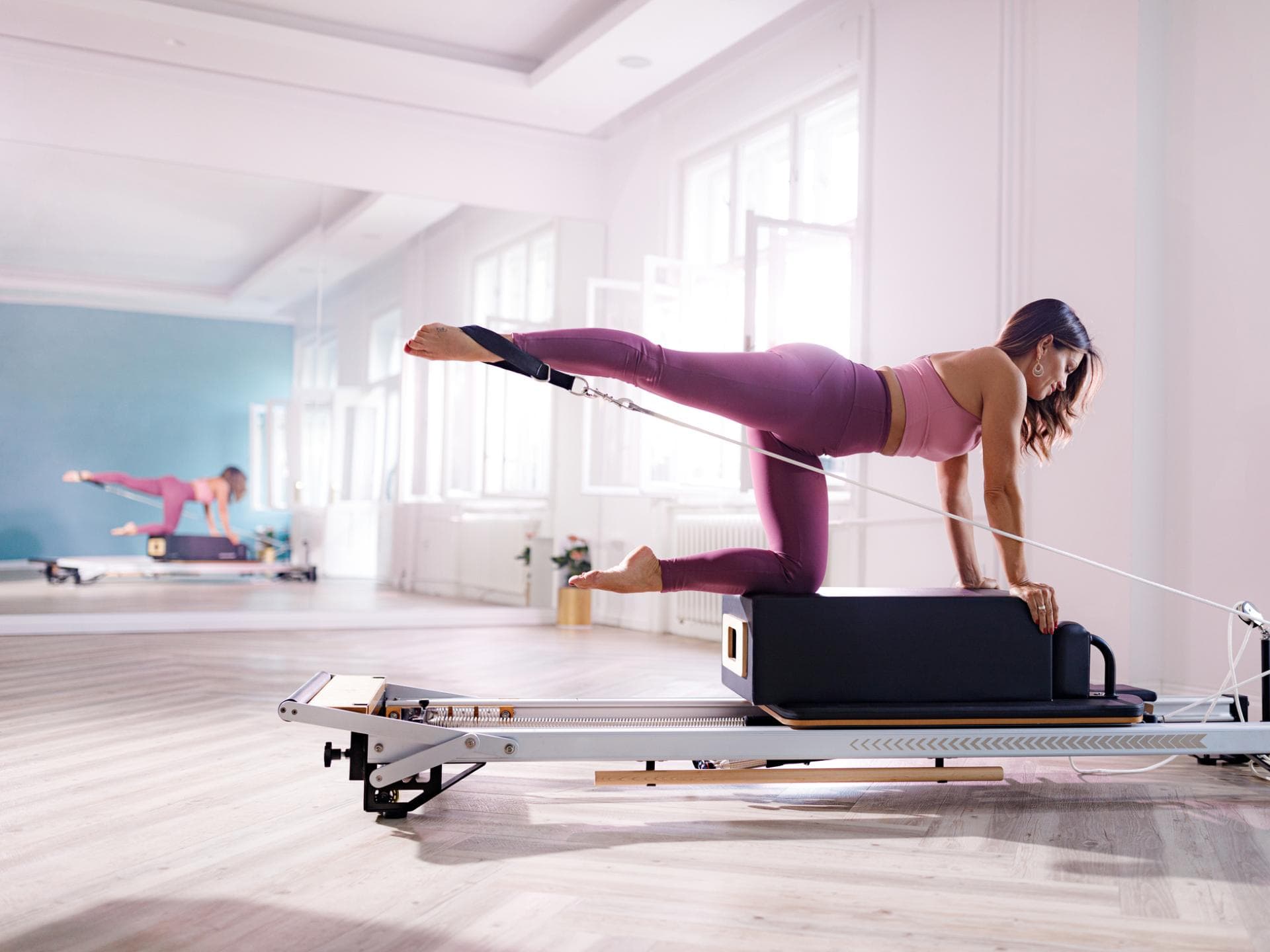 Frau trainiert mit Pilates Reformer