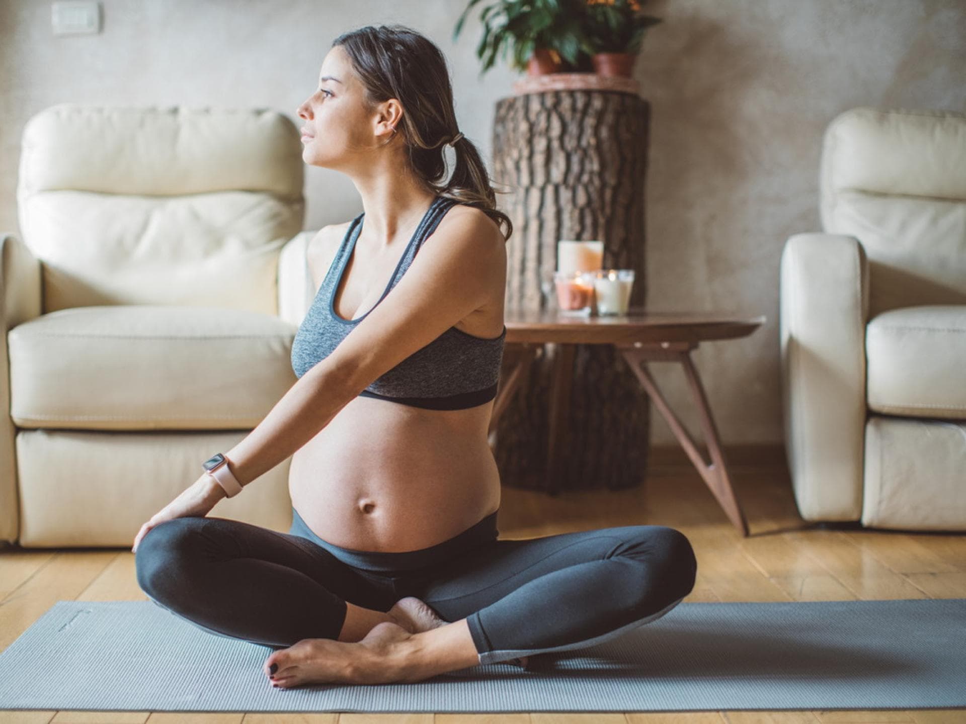 Schwangere Frau auf Fitnessmatte