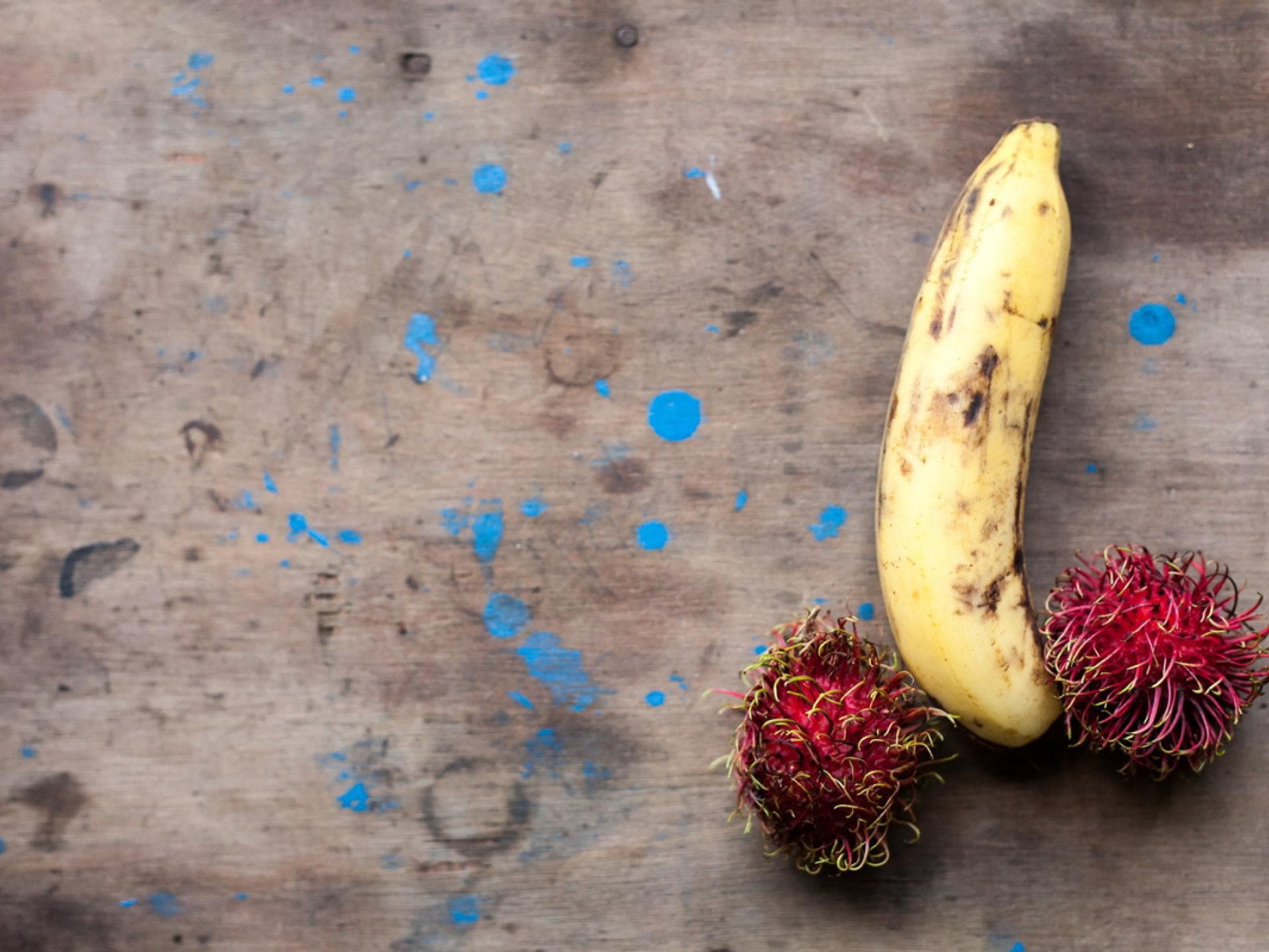 Was kann hinter dem Ausschlag am Penis stecken? Rambutan und Banane symbolisch zu Penis mit Hoden angeordnet