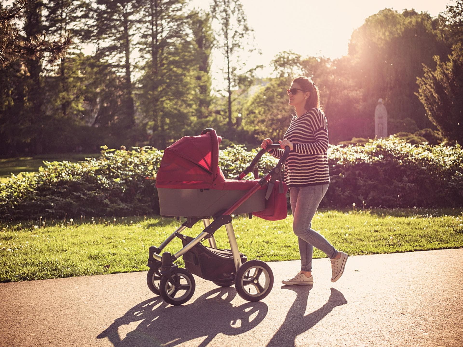 Mutter schiebt Kind im Kinderwagen