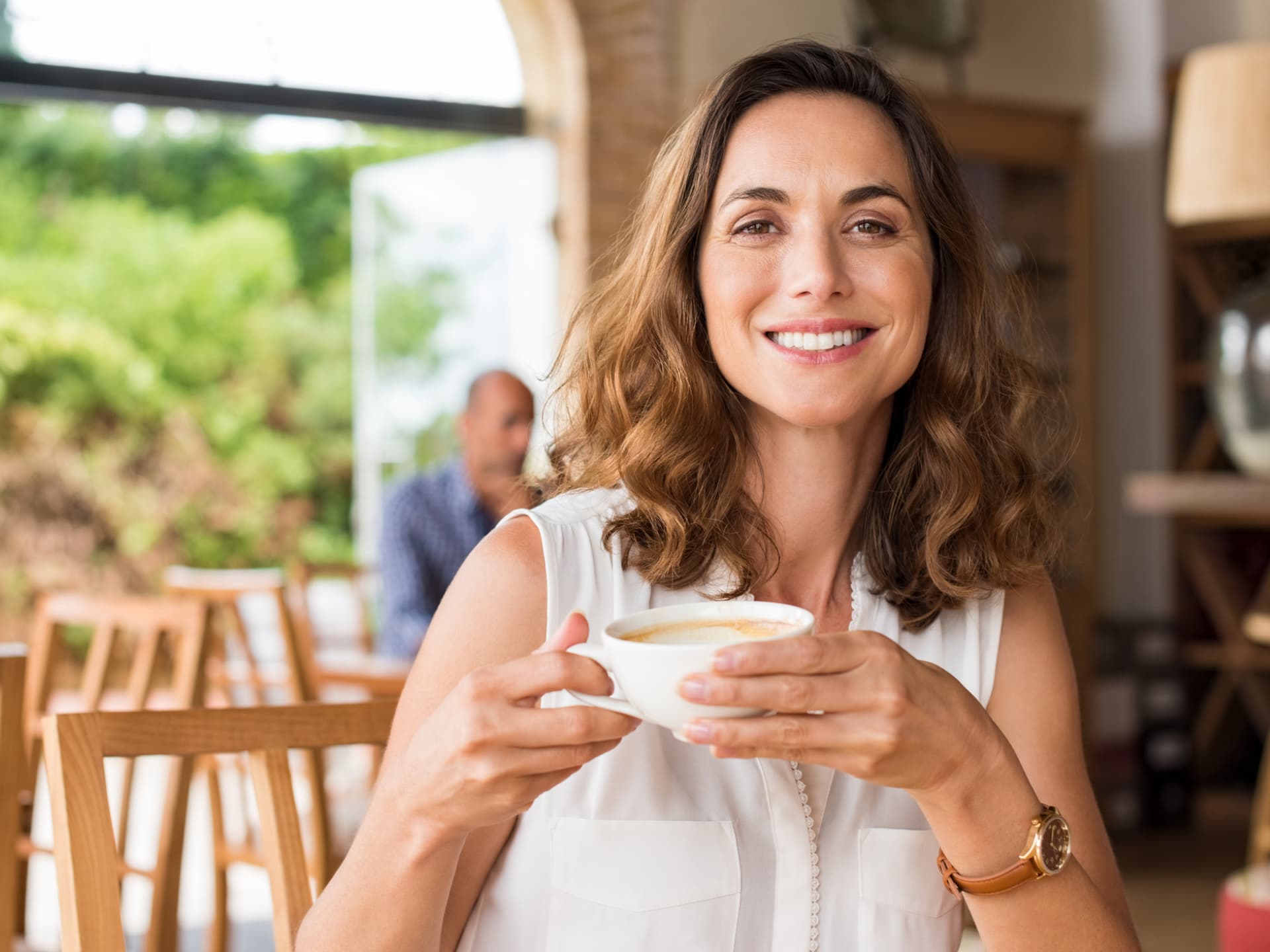 Die Suche nach Ihrem Ikigai ist eine Reise, kein Ziel. Frau trinkt lächelnd eine Tasse Kaffee