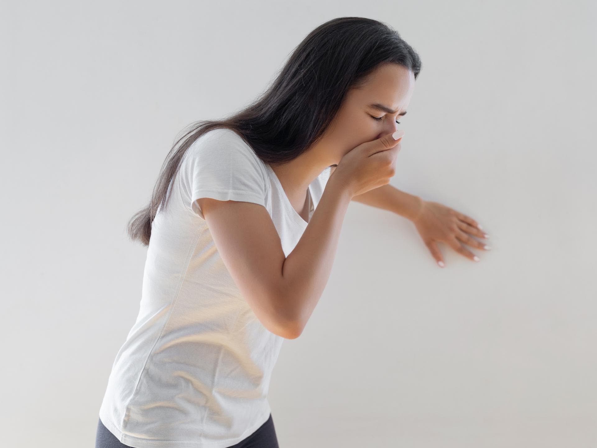Frau ist übel und sie hält sich die Hand vor den Mund Frau ist übel und sie hält sich die Hand vor den Mund