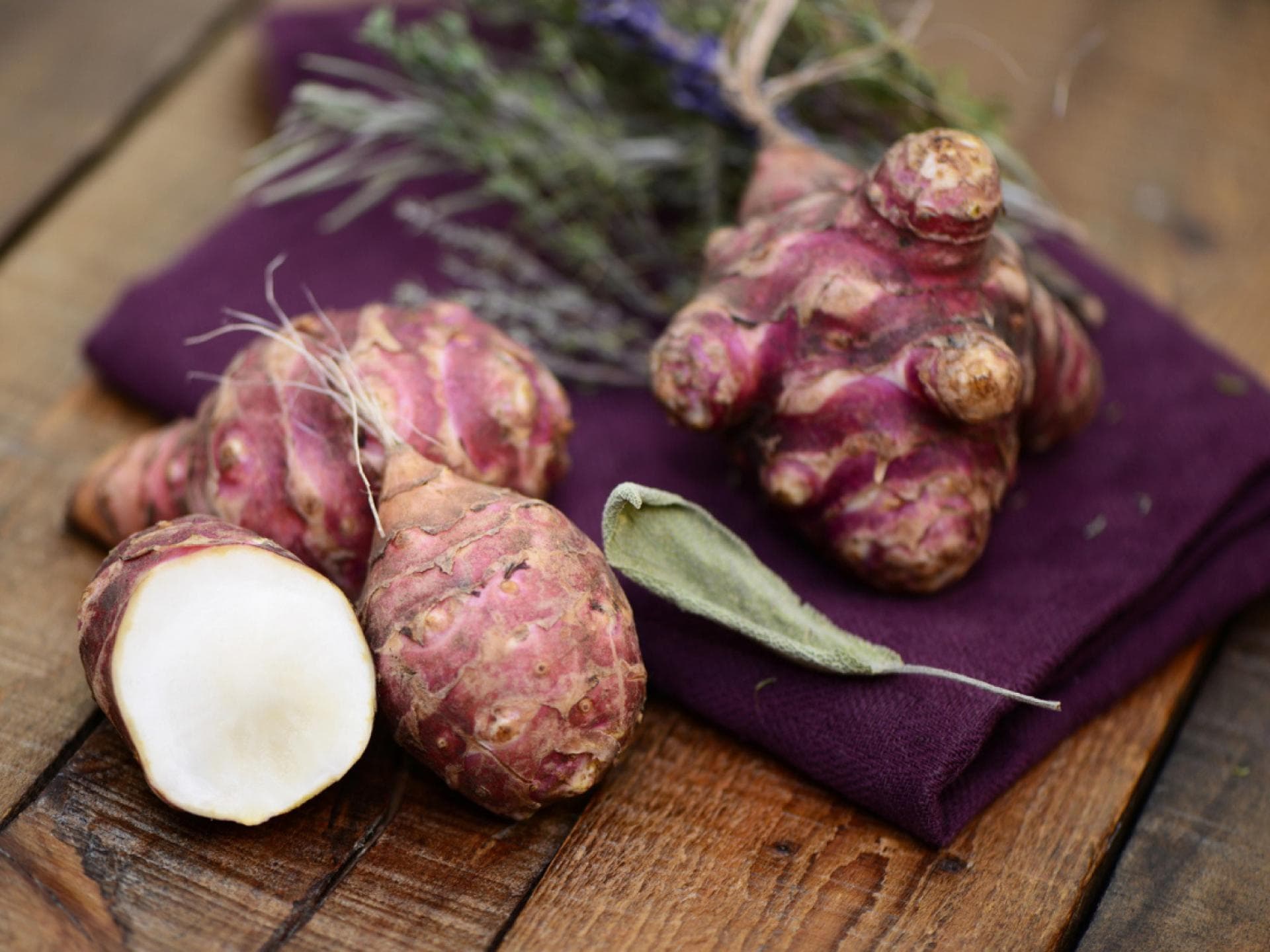 So gesund ist Topinambur Aufgeschnittene Topinambur auf einem Holztisch