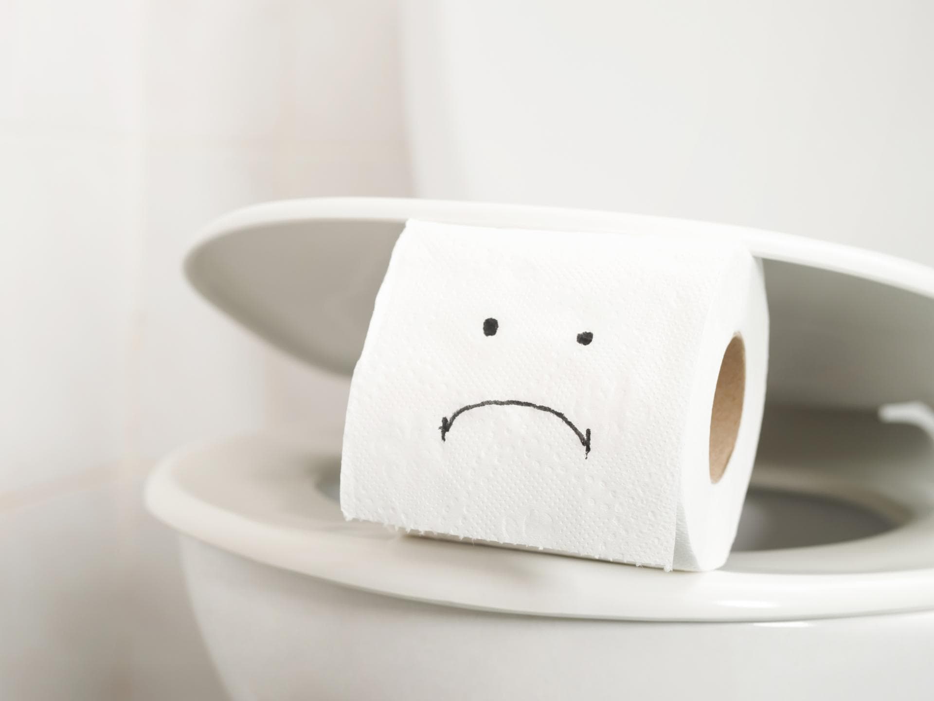 Rolle Toilettenpapier mit einem traurigen Gesicht drauf