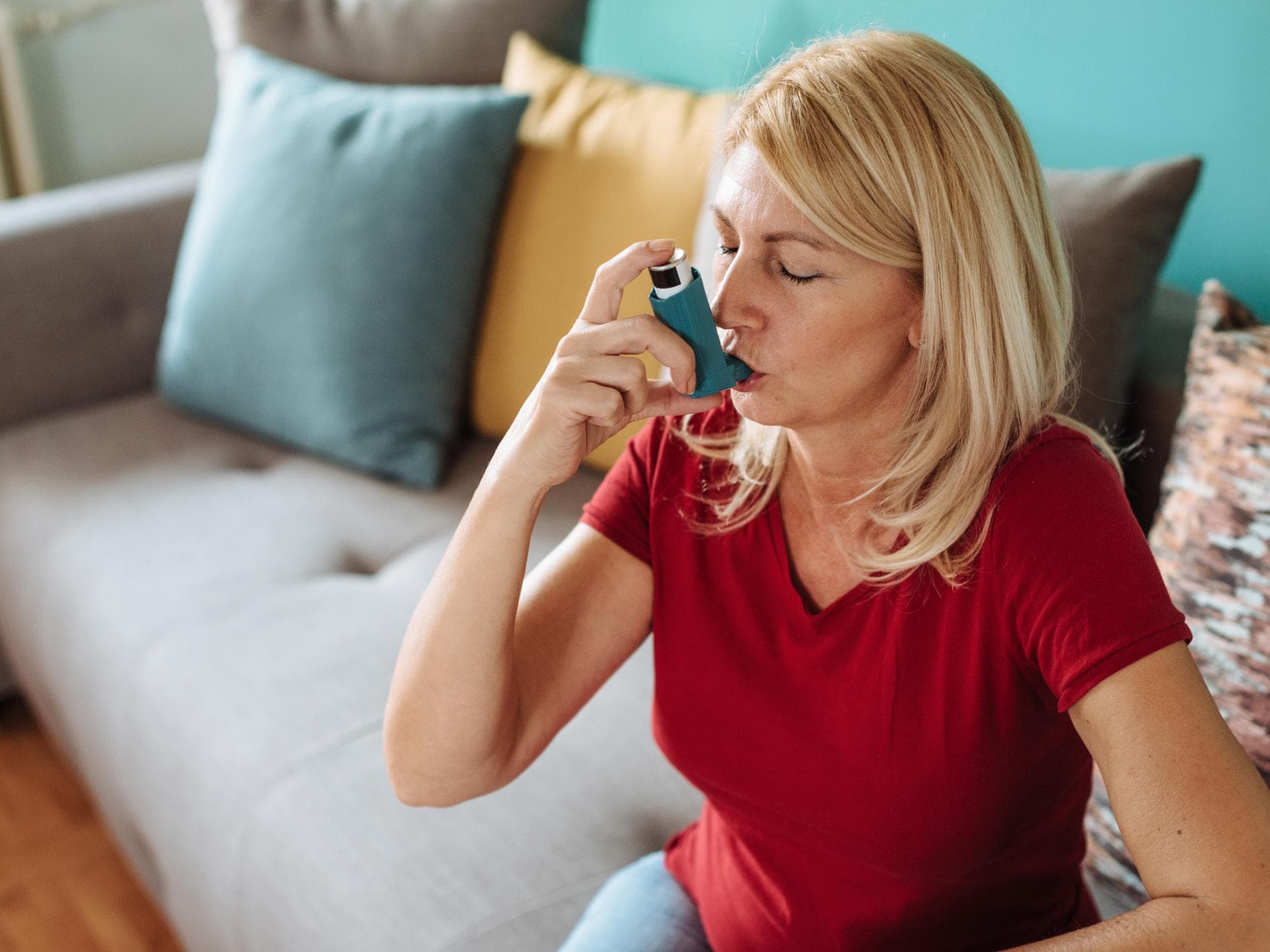 Frau hat allergisches Asthma und nutzt einen Inhalator.