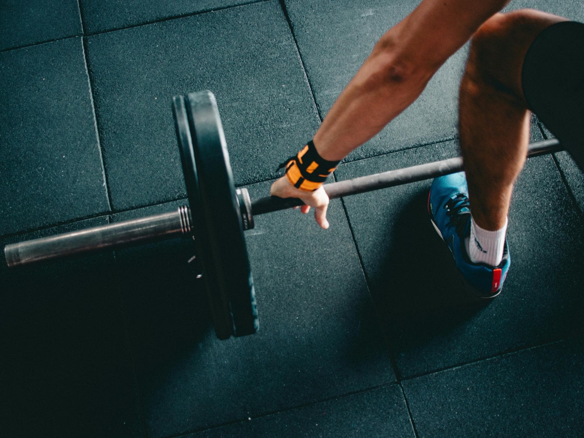 Mann im Fitnessstudio mit Hantelstange