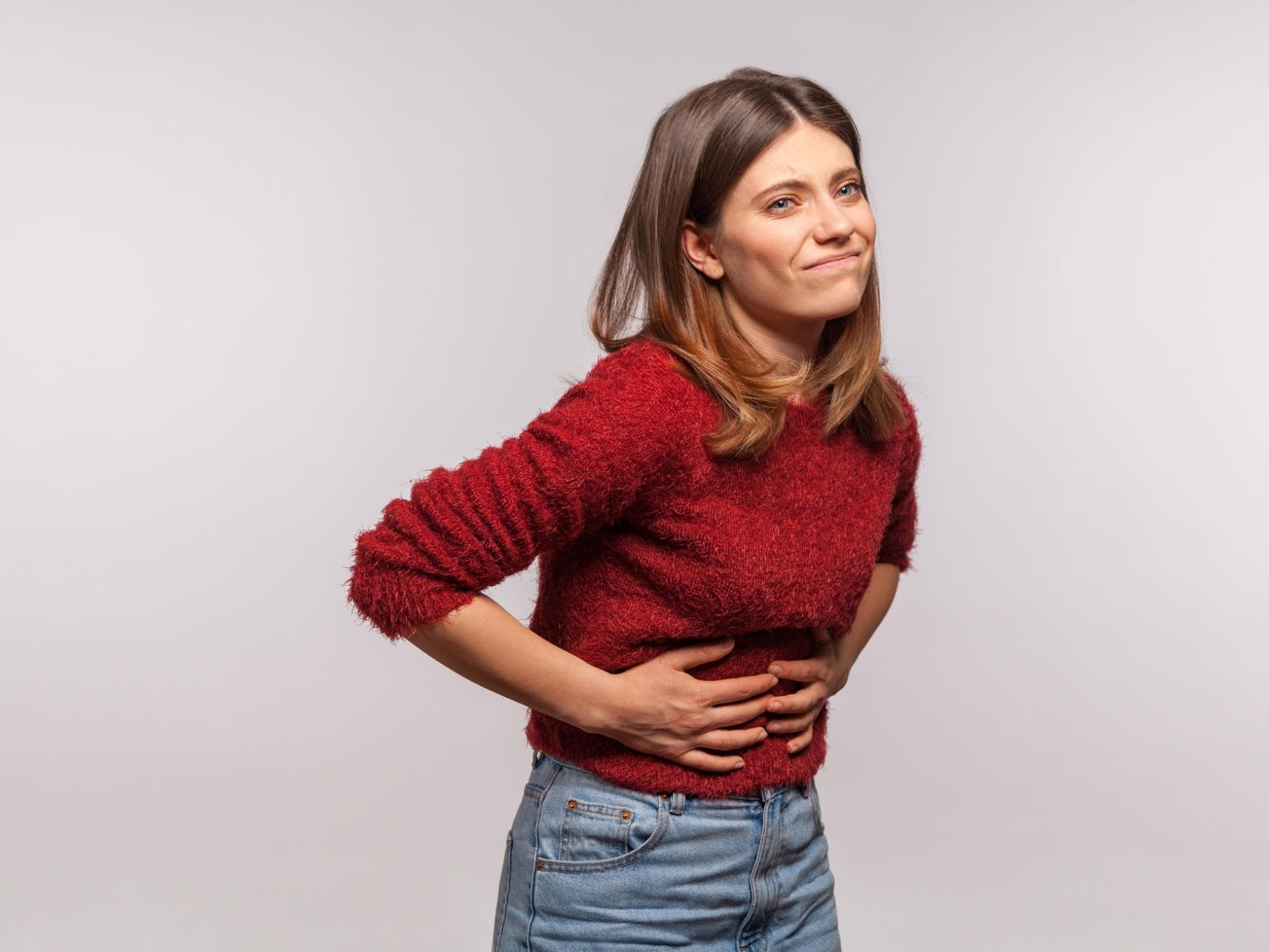 Frau hält sich den Bauch, weil sie Hunger hat Frau hält sich den Bauch, weil sie Hunger hat