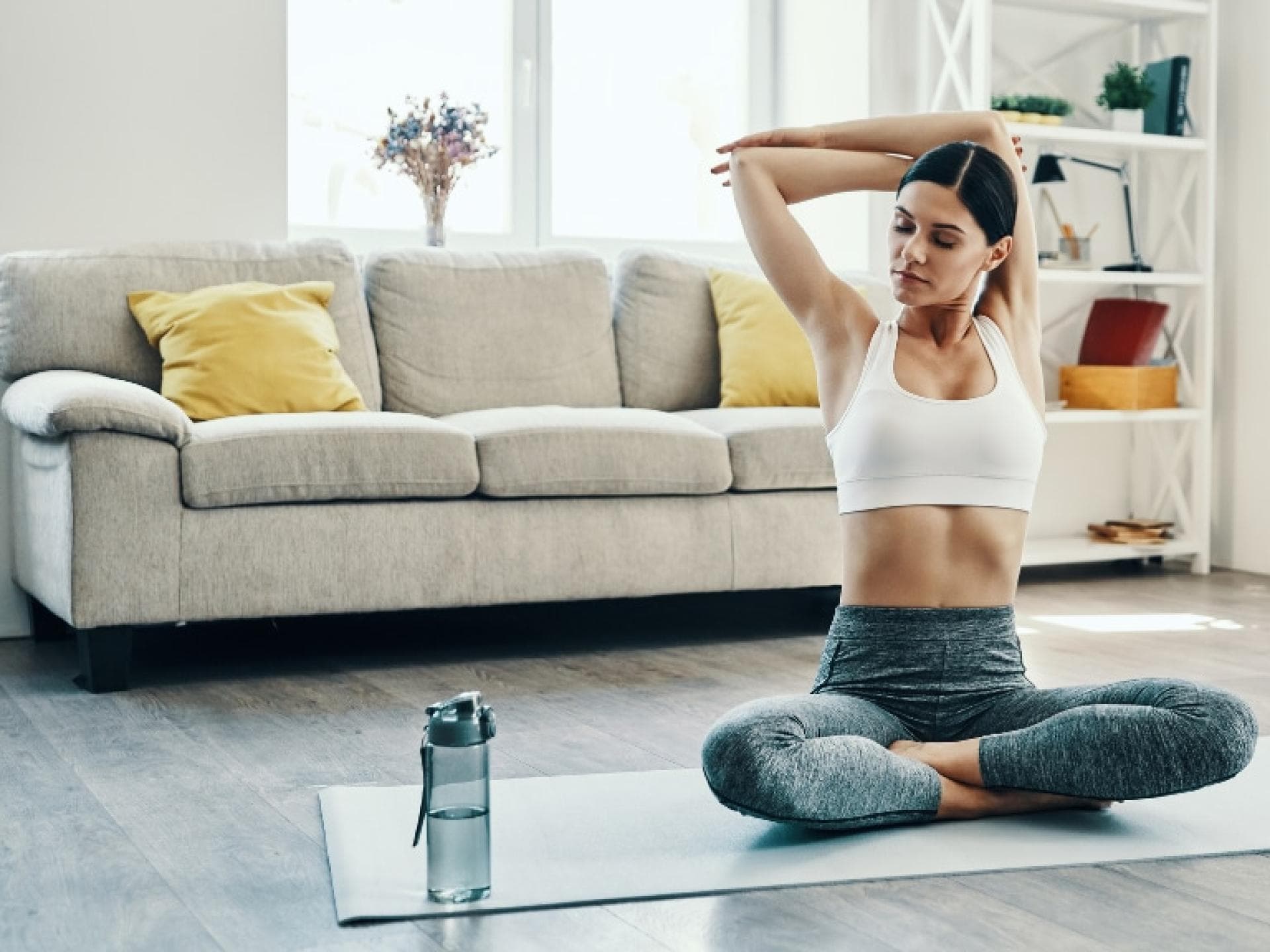 Frau dehnt sich auf der Yogamatte