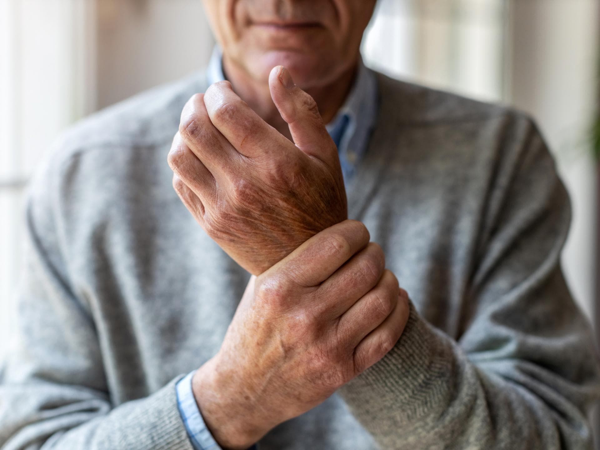 Mann hält sich die schmerzende Hand