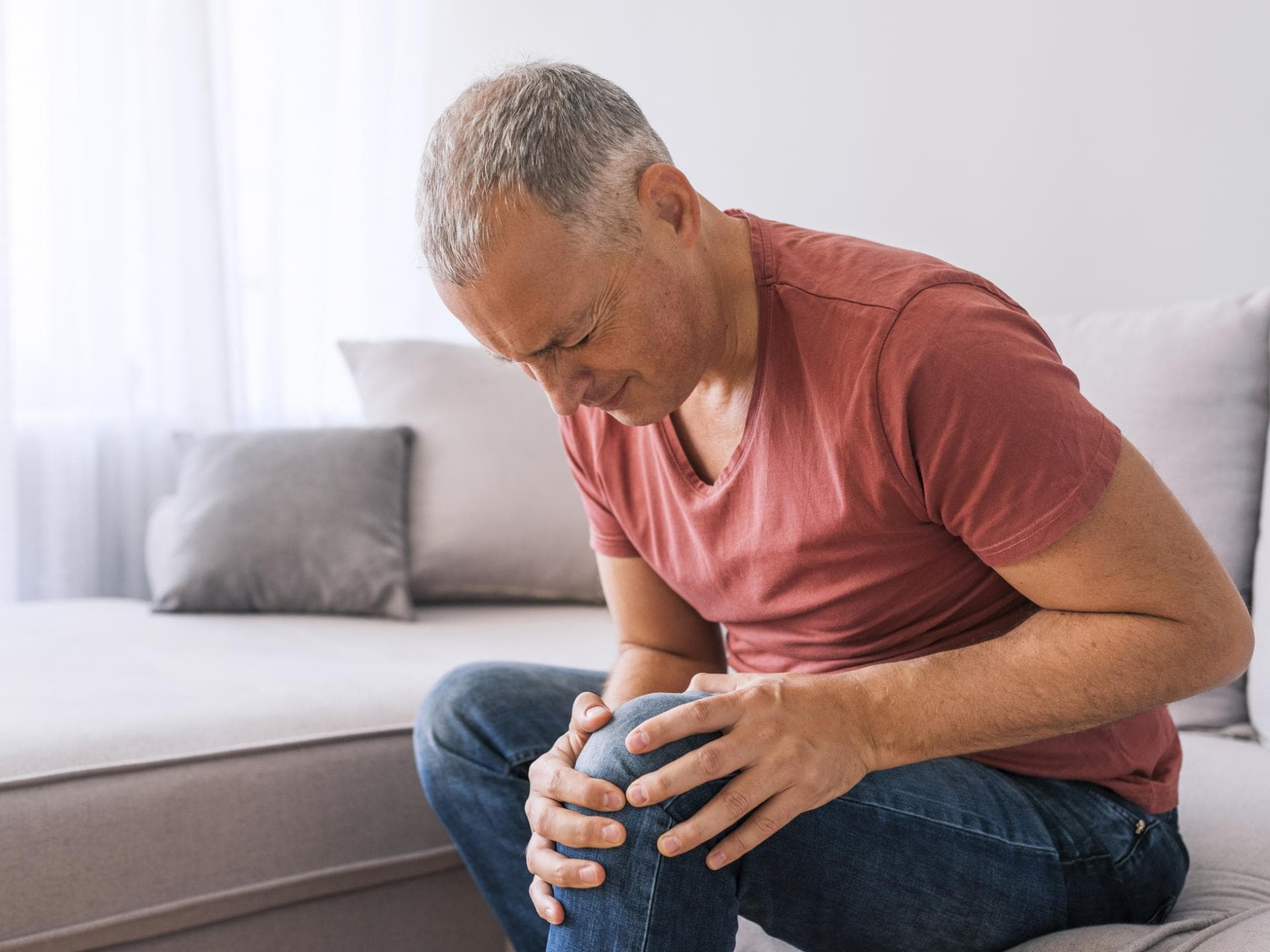 Ein Mann hält sich vor Schmerzen wegen einer Gelenkerkrankung das Knie.