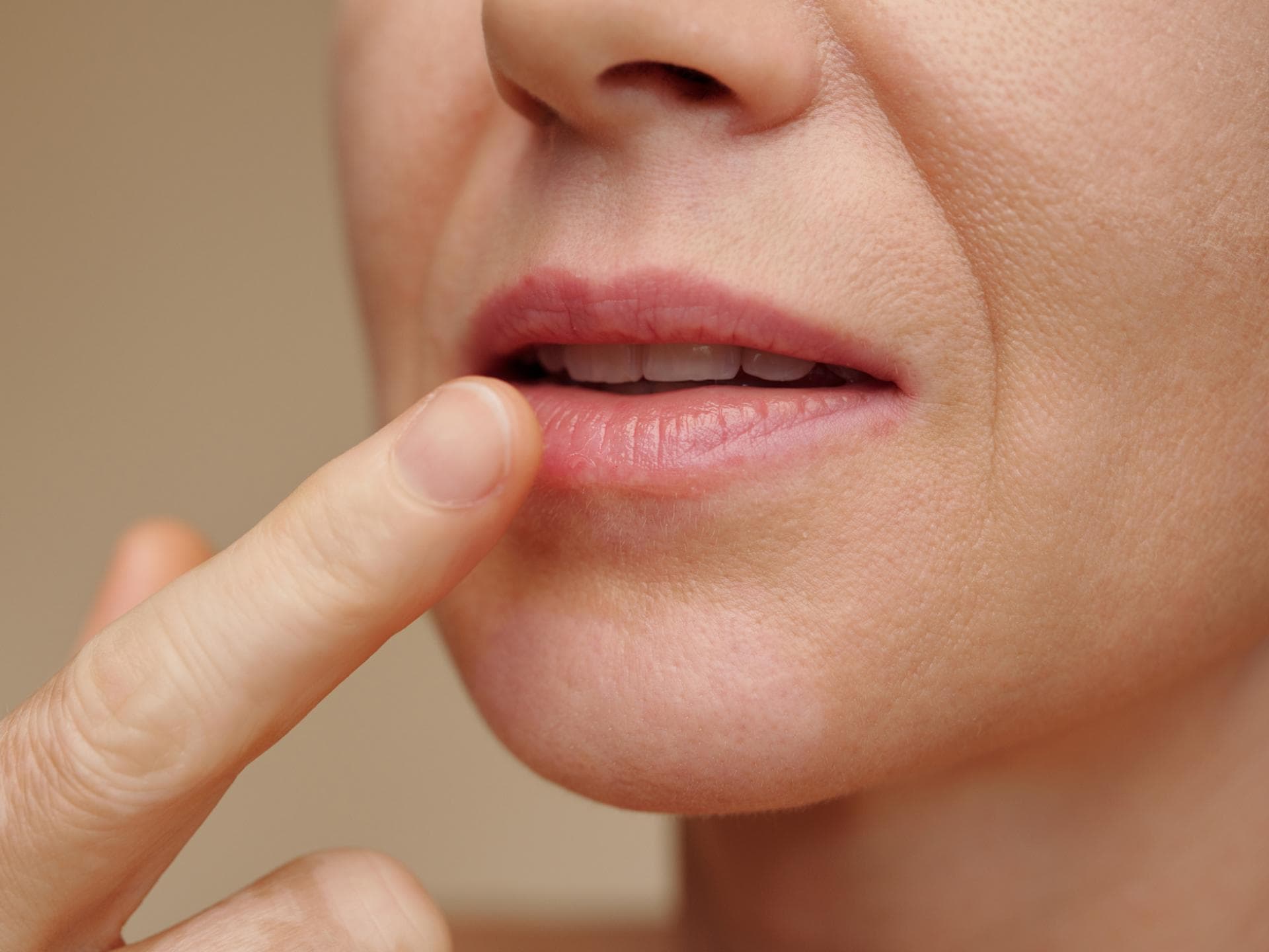 Frau fasst mit dem Finger an ihre Lippe Frau fasst mit dem Finger an ihre Lippe