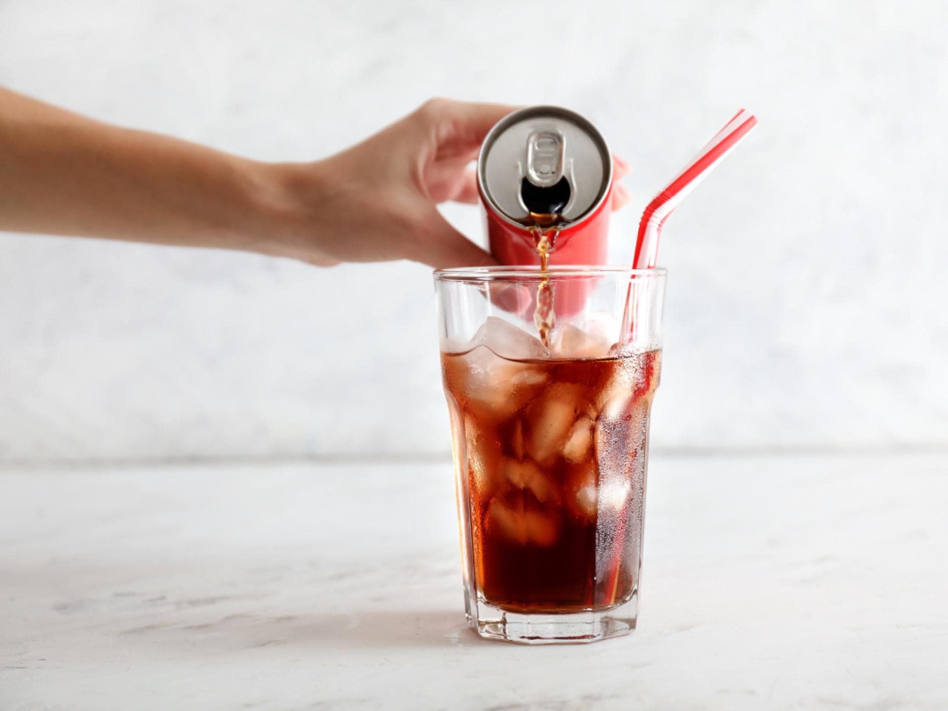Cola wird in ein Glas eingegossen Cola wird in ein Glas eingegossen