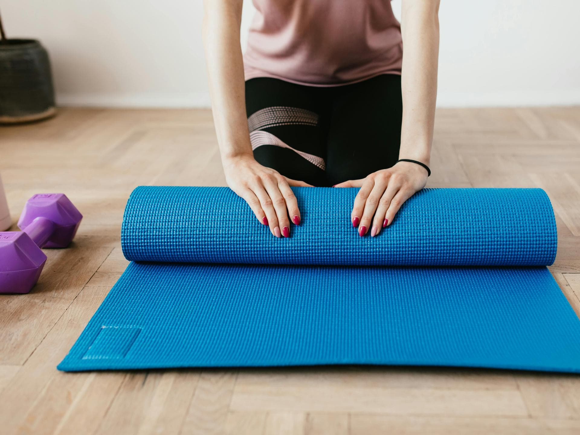 Frau rollt Sportmatte zusammen