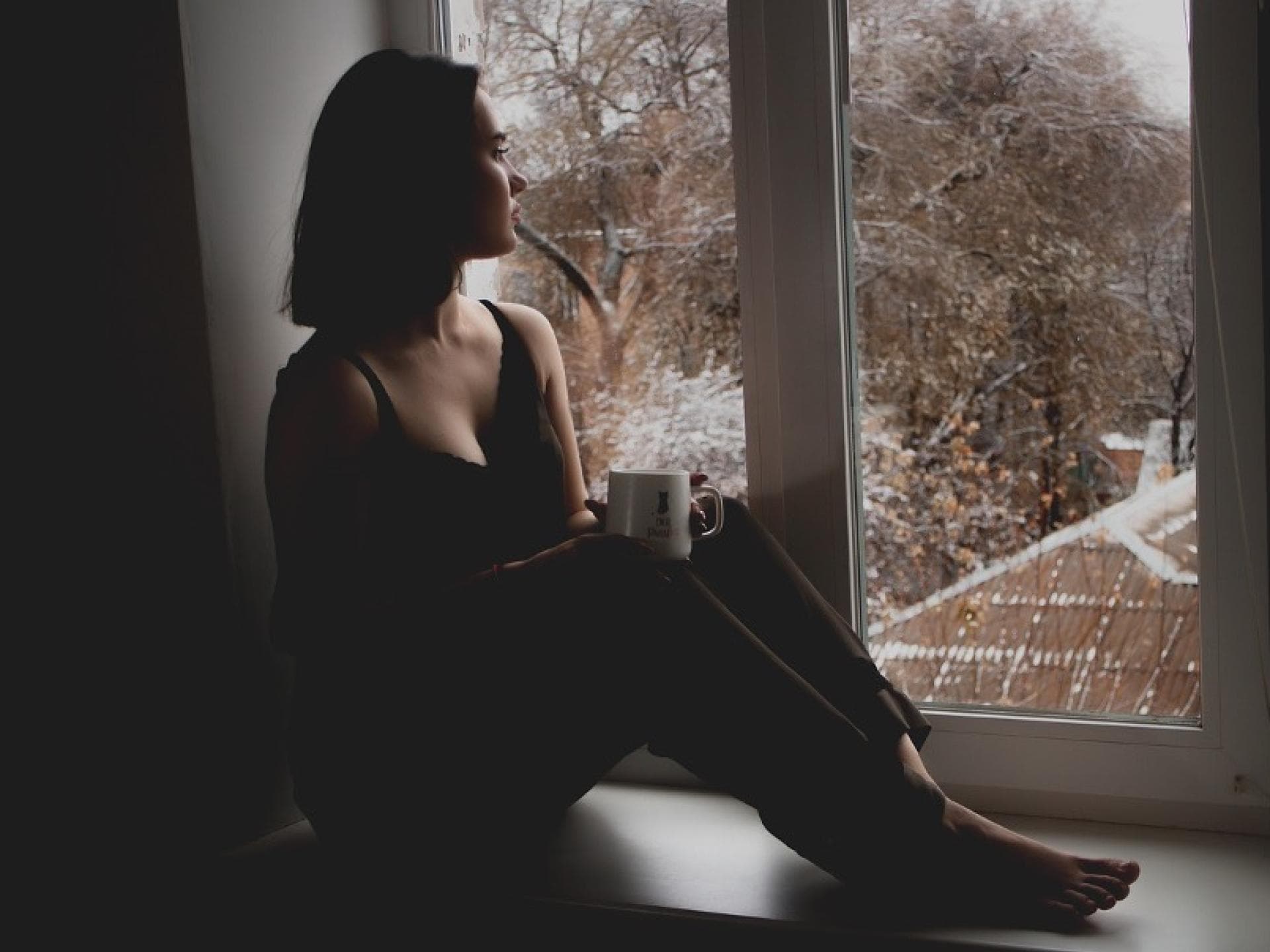 Junge Frau sitzt am Fenster