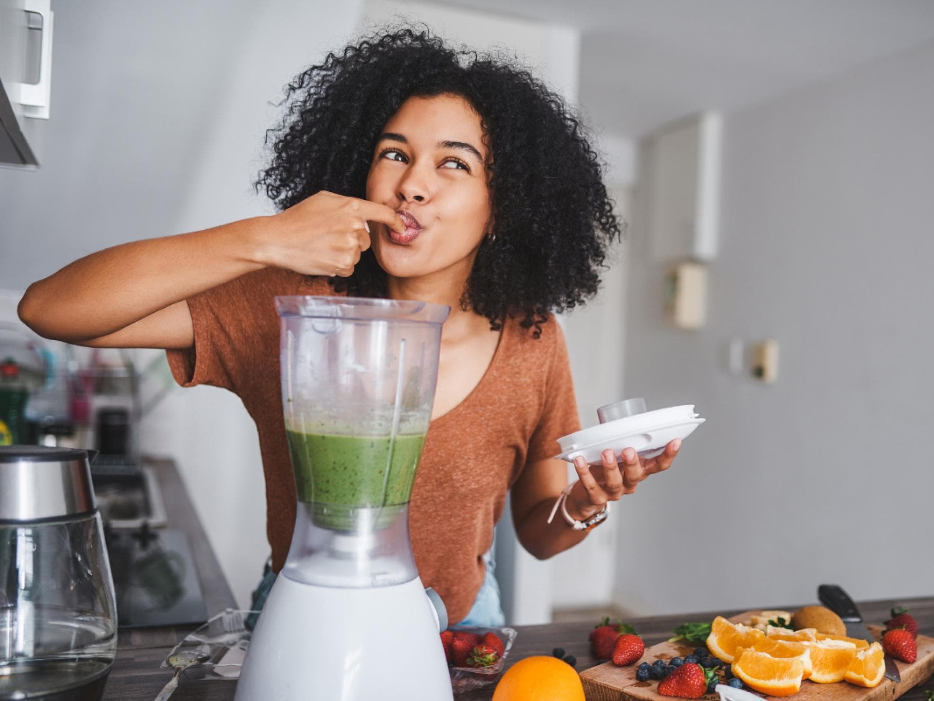 Junge Frau mixt einen Shake