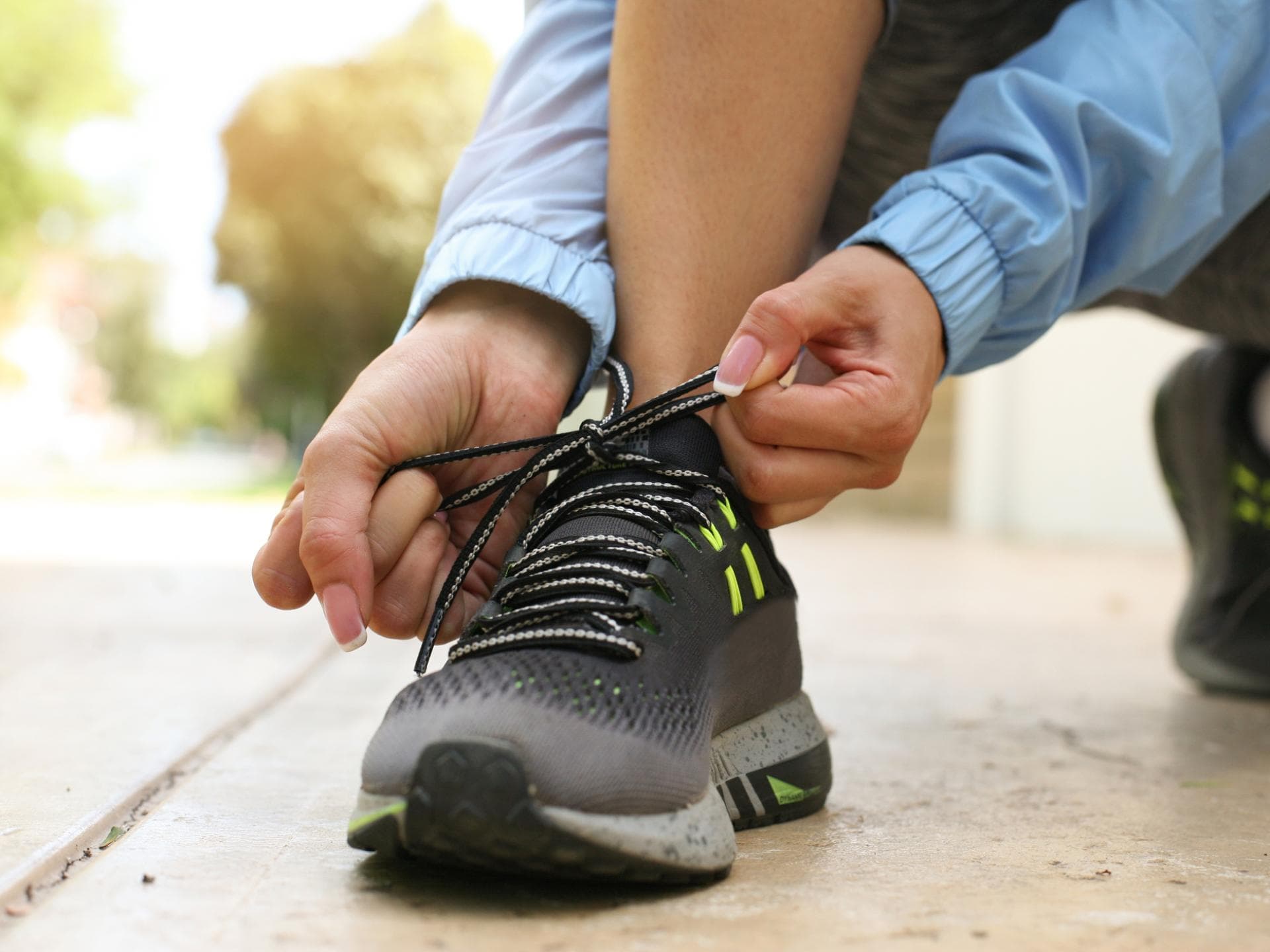 Eine Frau bindet sich die Schuhe zu