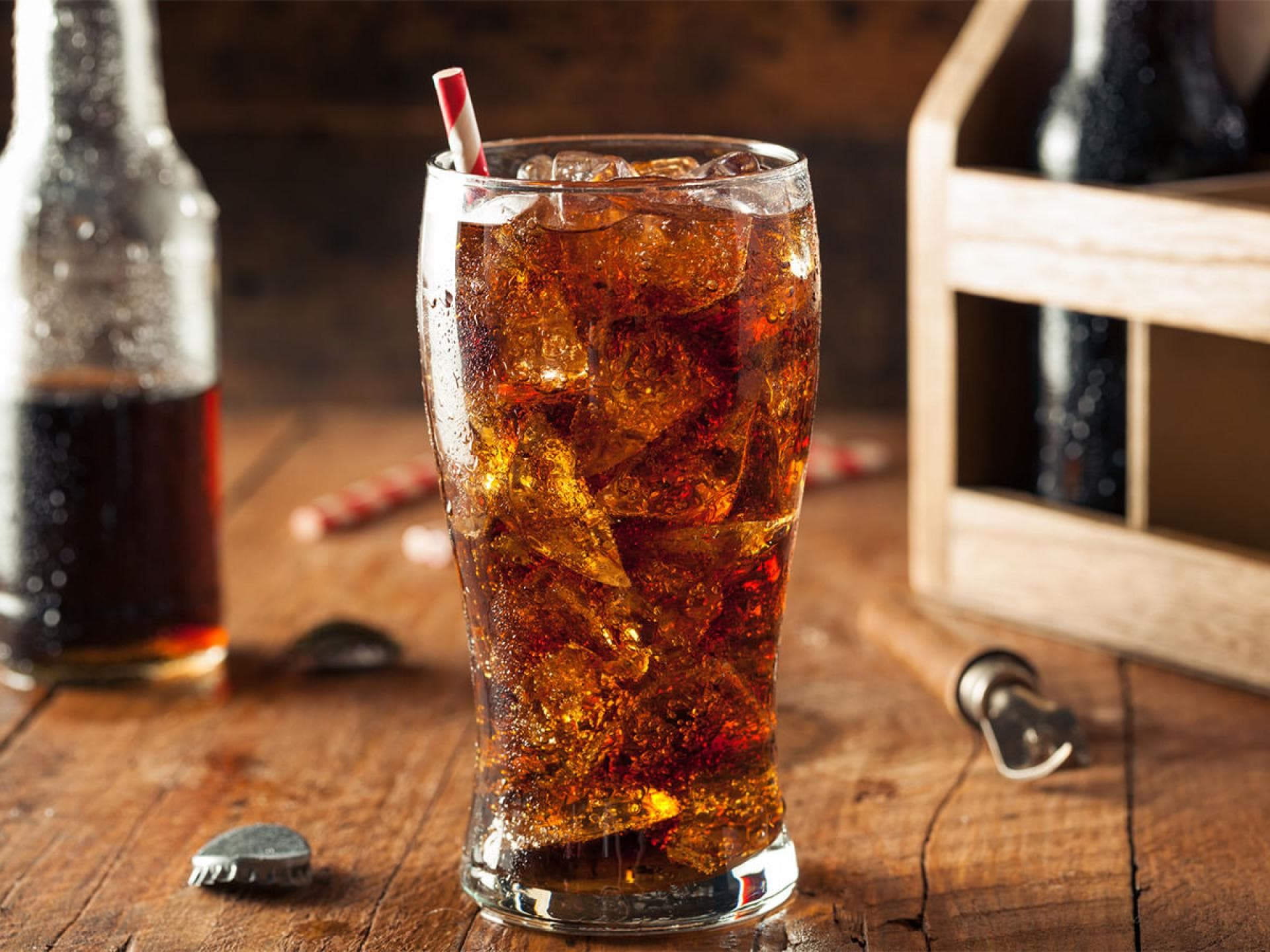 Ein Glas Cola mit Eiswürfeln und Strohhalm
