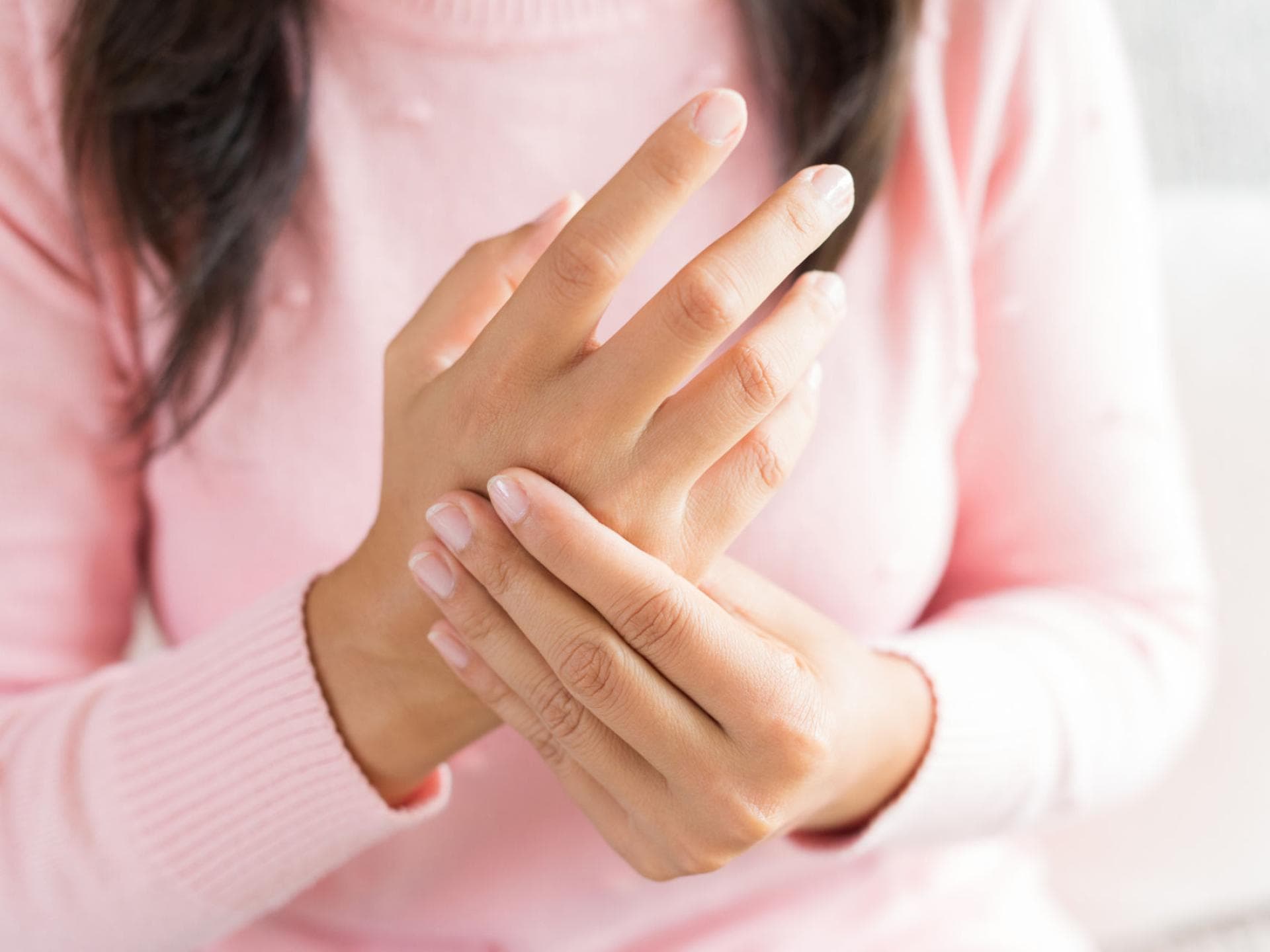 Frau_Hände Frau hält sich die Hand