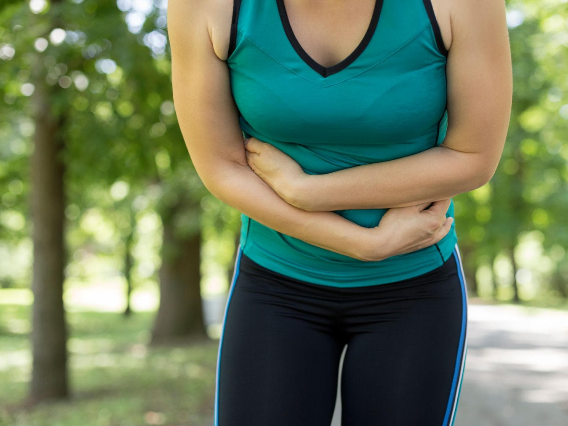 Frau beim Sport mit Bauchschmerzen