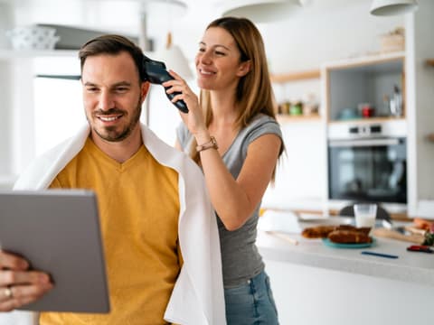 Frau schneidet Mann die Haare