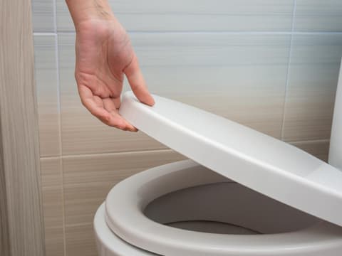 Hand am Toilettendeckel