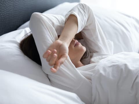 Kranke Frau liegt im Bett
