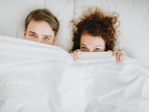 Paar liegt zusammen im Bett