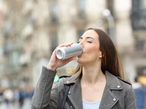 Frau trinkt aus Dose
