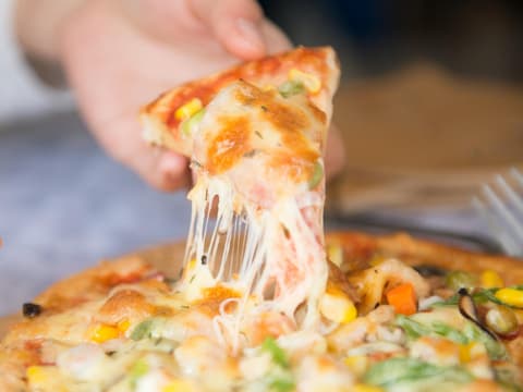 Ein Stück Pizza mit Käsefäden